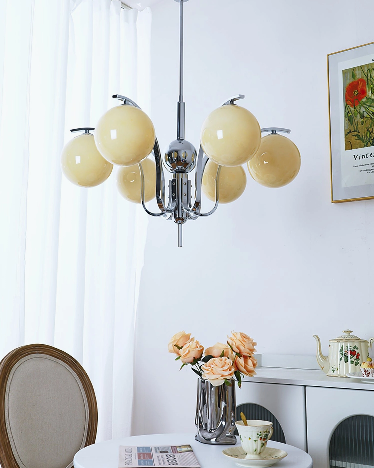 6-head creamy yellow glass globe chandelier overhead view in bright dining room with floral wall art