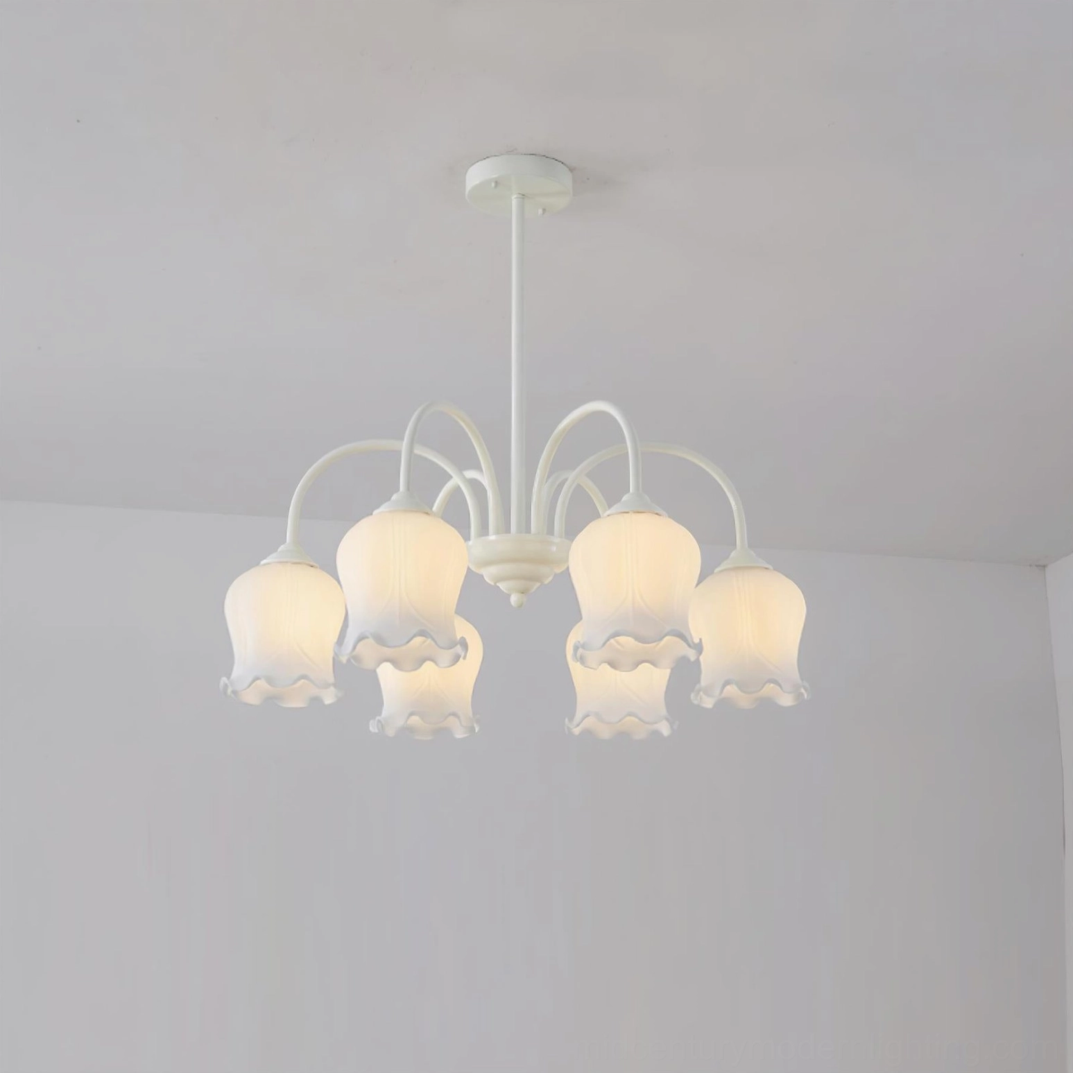 Six-head lily chandelier close-up showing frosted glass petal-shaped shades and white metal support structure