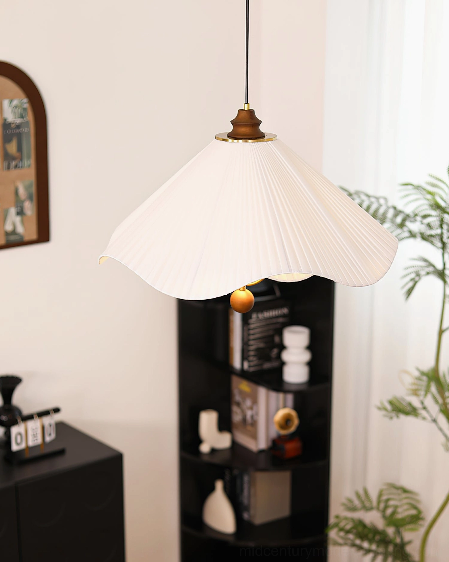 Sloane pendant light right side close-up displayed above black home storage shelf in bookshelf setting showing fabric pleating detail