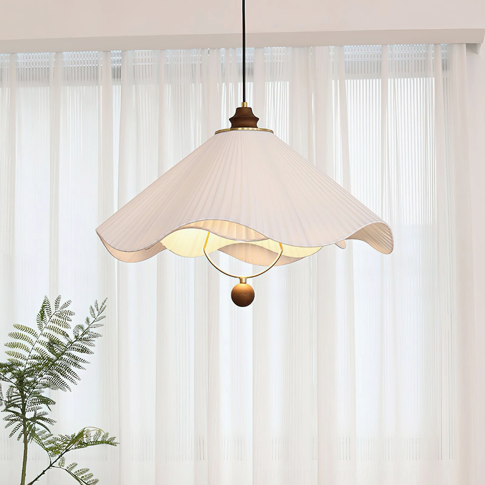 Sloane pleated pendant lamp right side close-up with sheer curtain backdrop showing warm interior glow and fabric texture detail