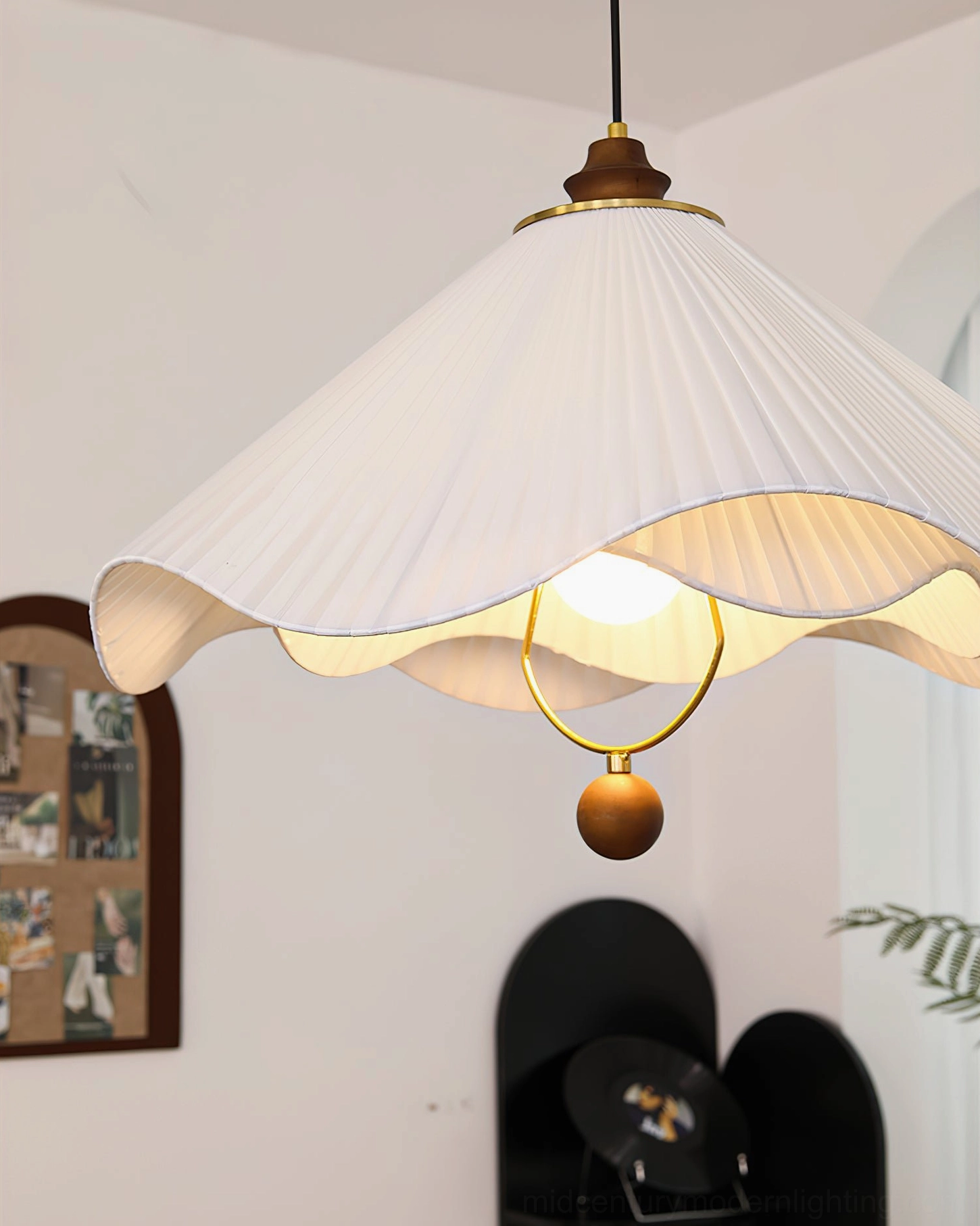 Sloane pleated pendant lamp low front close-up shot with arched wall decor background showing wider shade and golden metal hanging ring