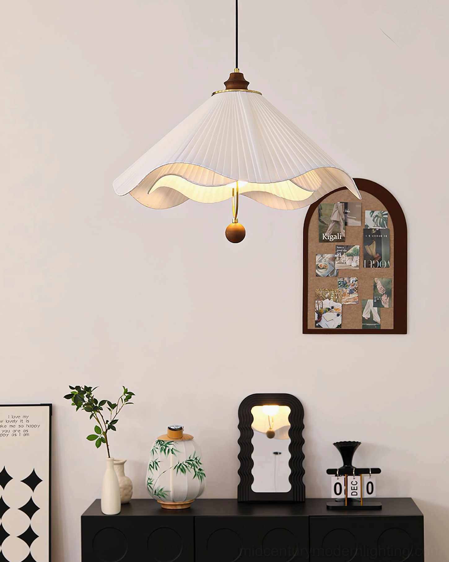 Sloane pleated fabric pendant lamp top-down three-quarter view in mid-century living area with black sideboard and wall photo display