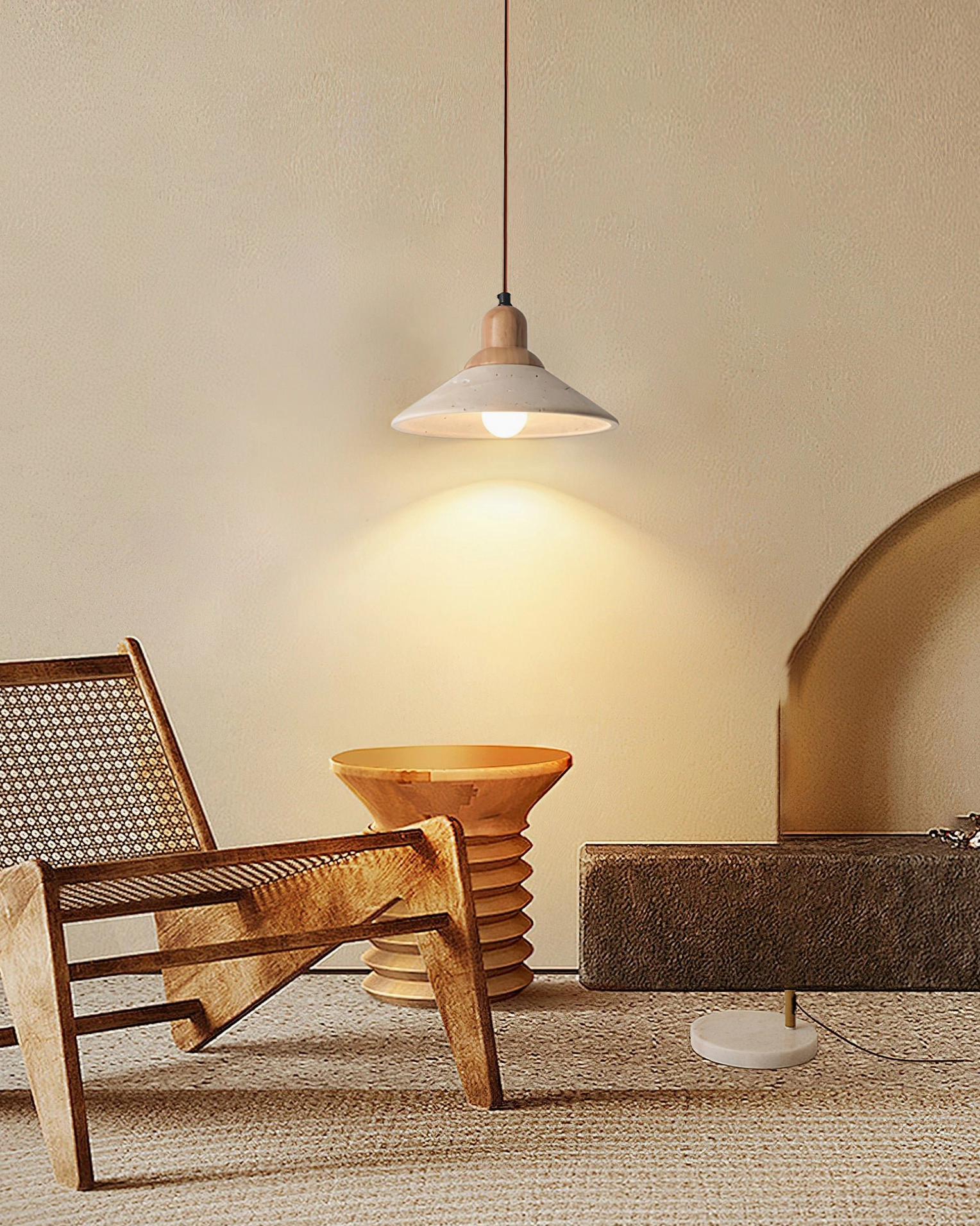 Solara travertine pendant in cozy living nook with arched wall, rattan chair, and textured rug