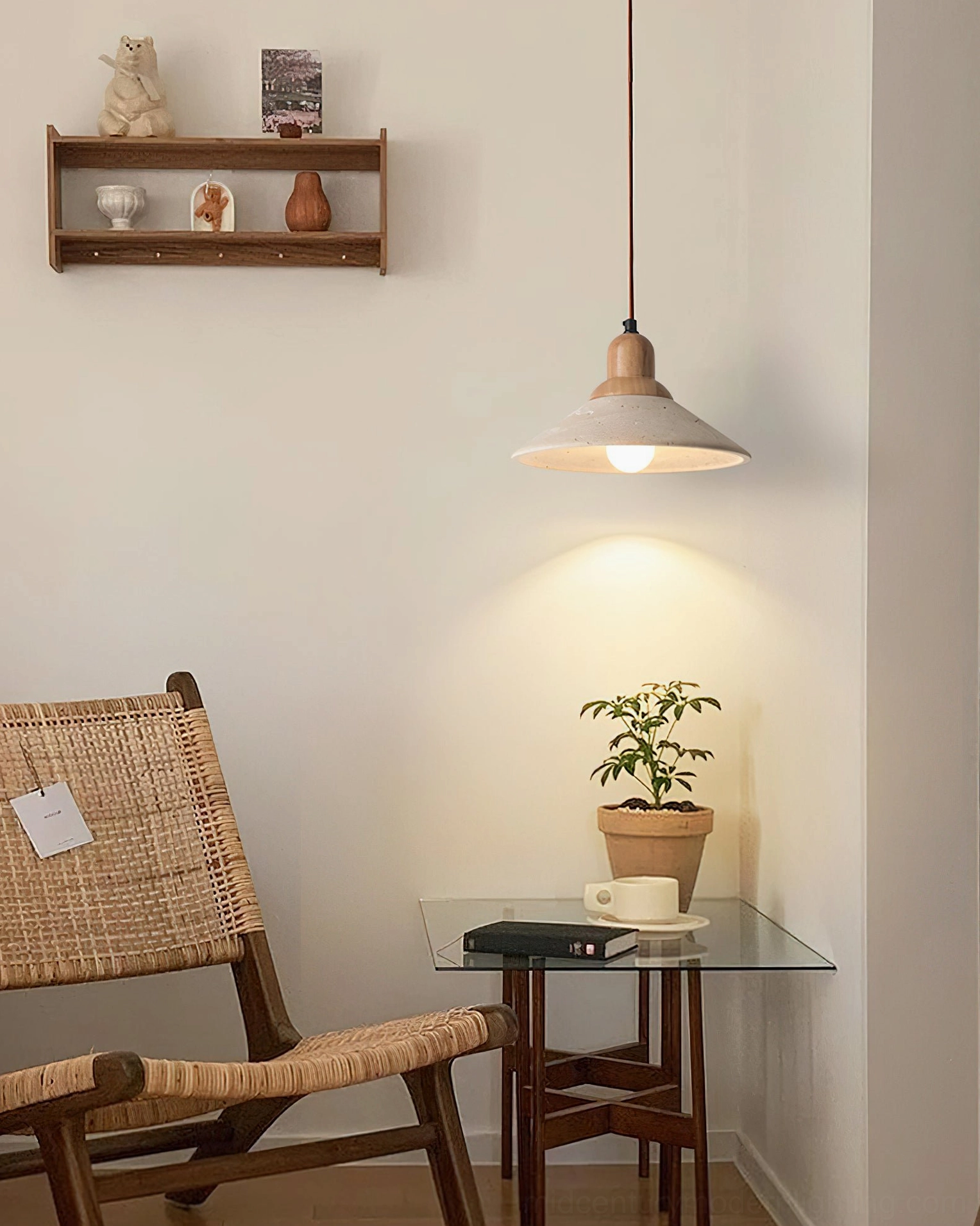 Solara pendant in minimalist reading nook with rattan chair, glass table, and potted plant