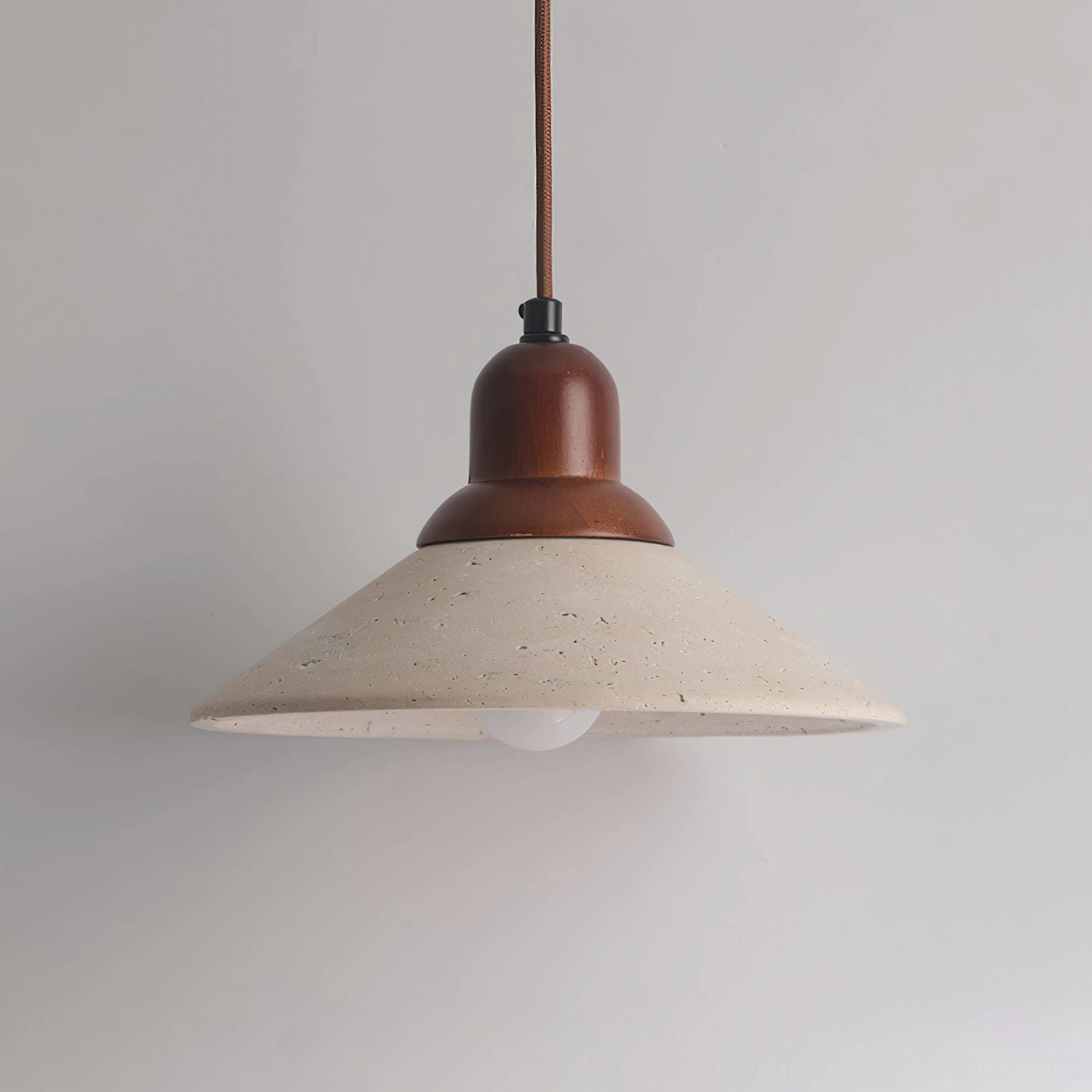 Solara pendant side view highlighting dark metal canopy, conical travertine shade, and exposed bulb design