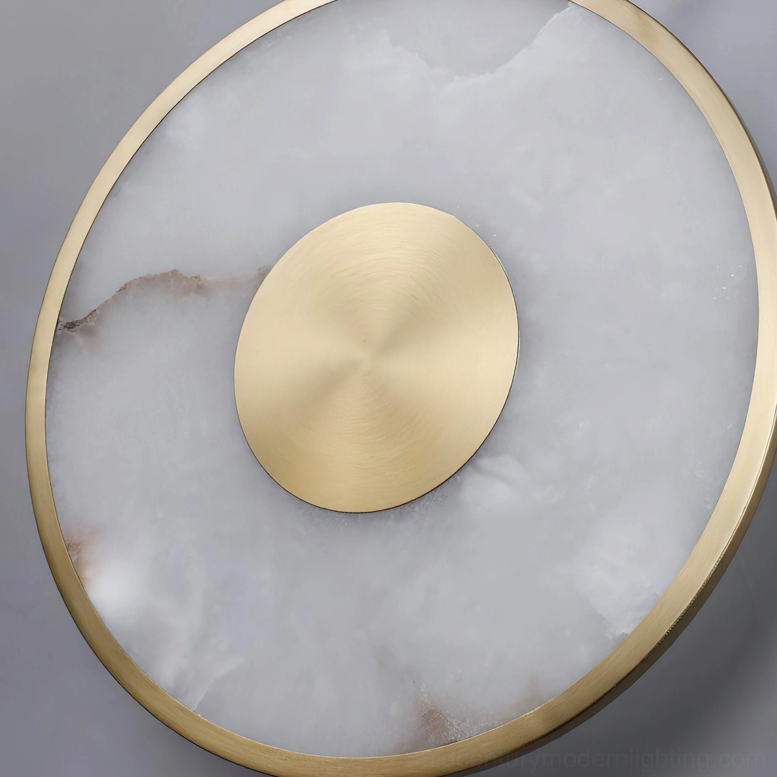 Sorle alabaster disc detail, top-down view showing veining pattern and brushed brass frame construction