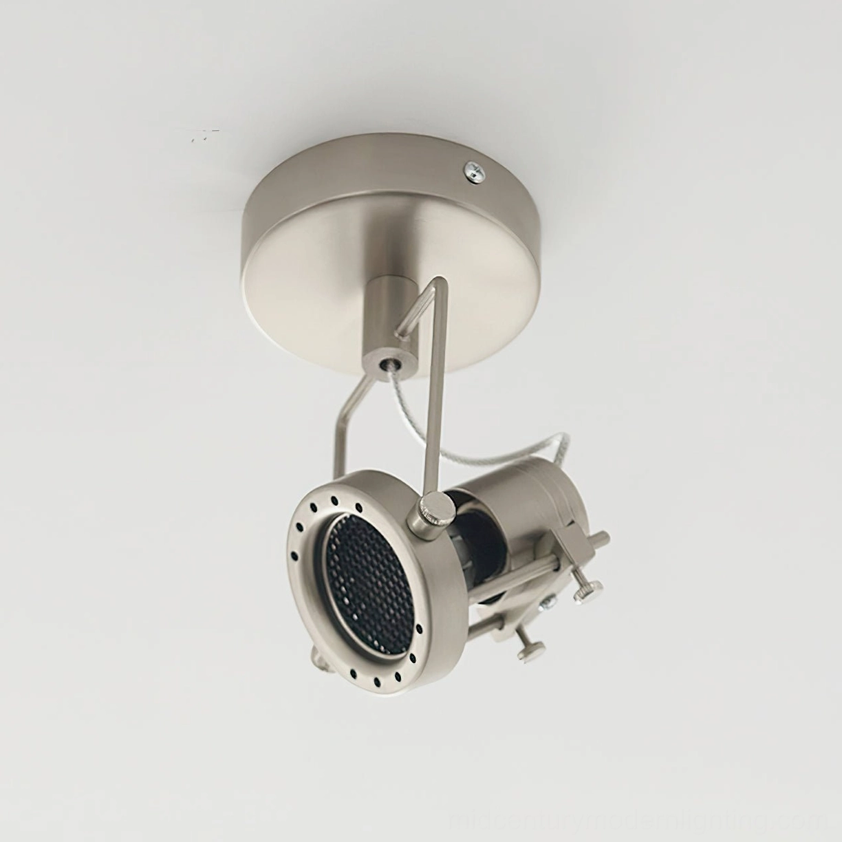 Bottom-up view of wall or ceiling mounted spotlight showing black reflector and perforated metal front cover design