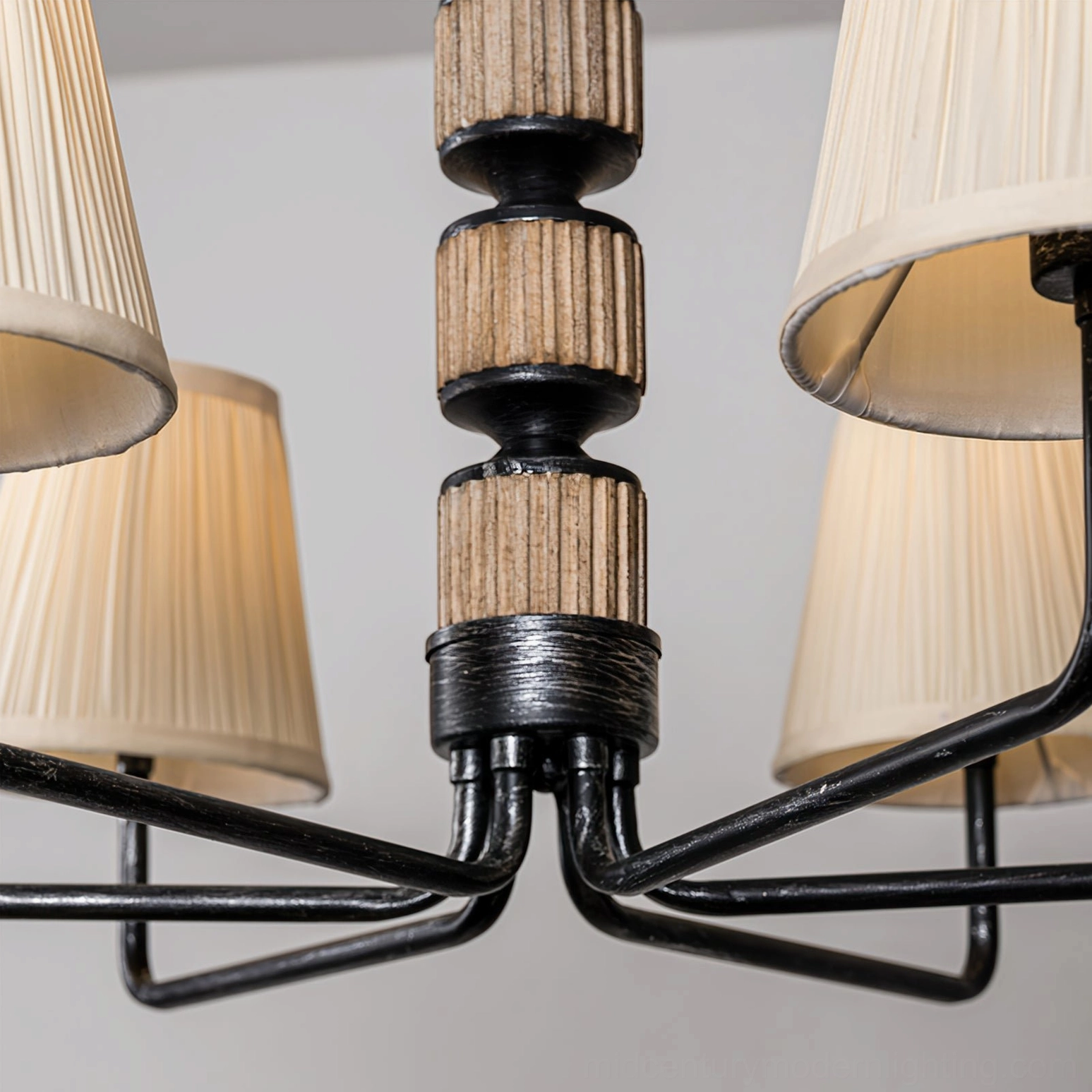 Close-up top-down view of Stacey chandelier central hardware joint detail showcasing black metal arms and fluted wood accents