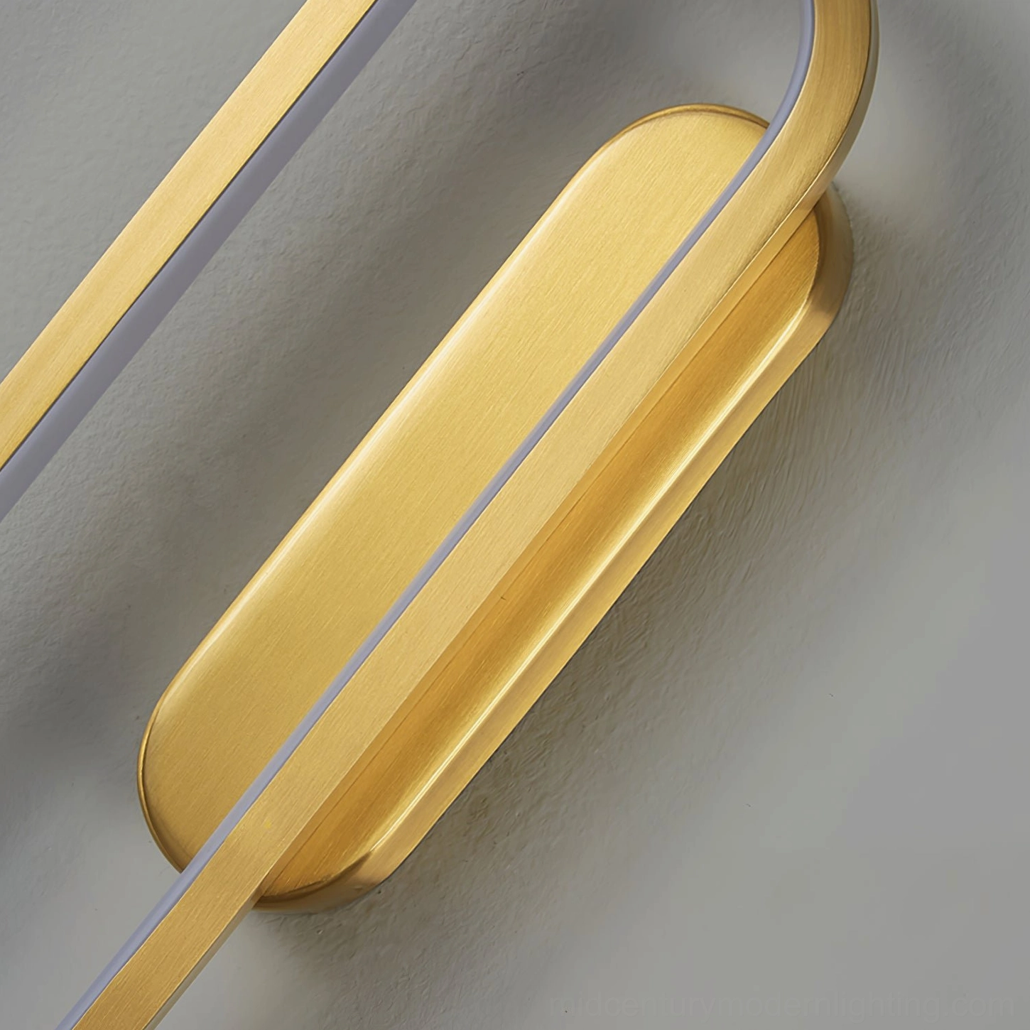 Close-up macro shot of Starkey wall lamp brushed brass hardware and curved slim metal frame detail