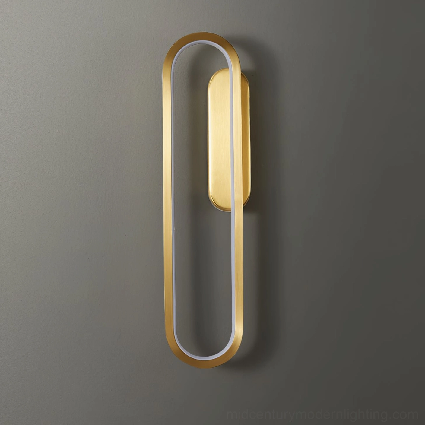 Vertical oval Starkey LED wall sconce with gold hollow frame and central warm light module on dark wall
