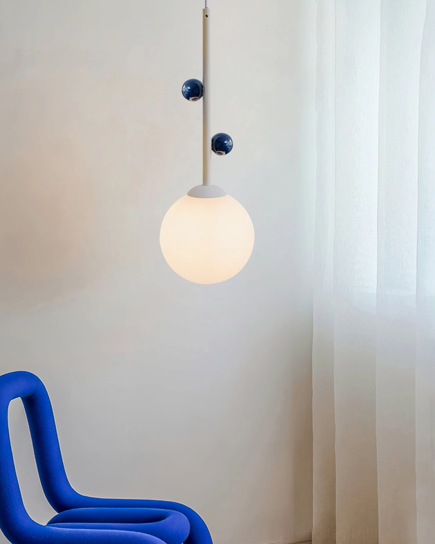 Stax pendant lamp with blue color accent details in minimalist living area with sheer curtains