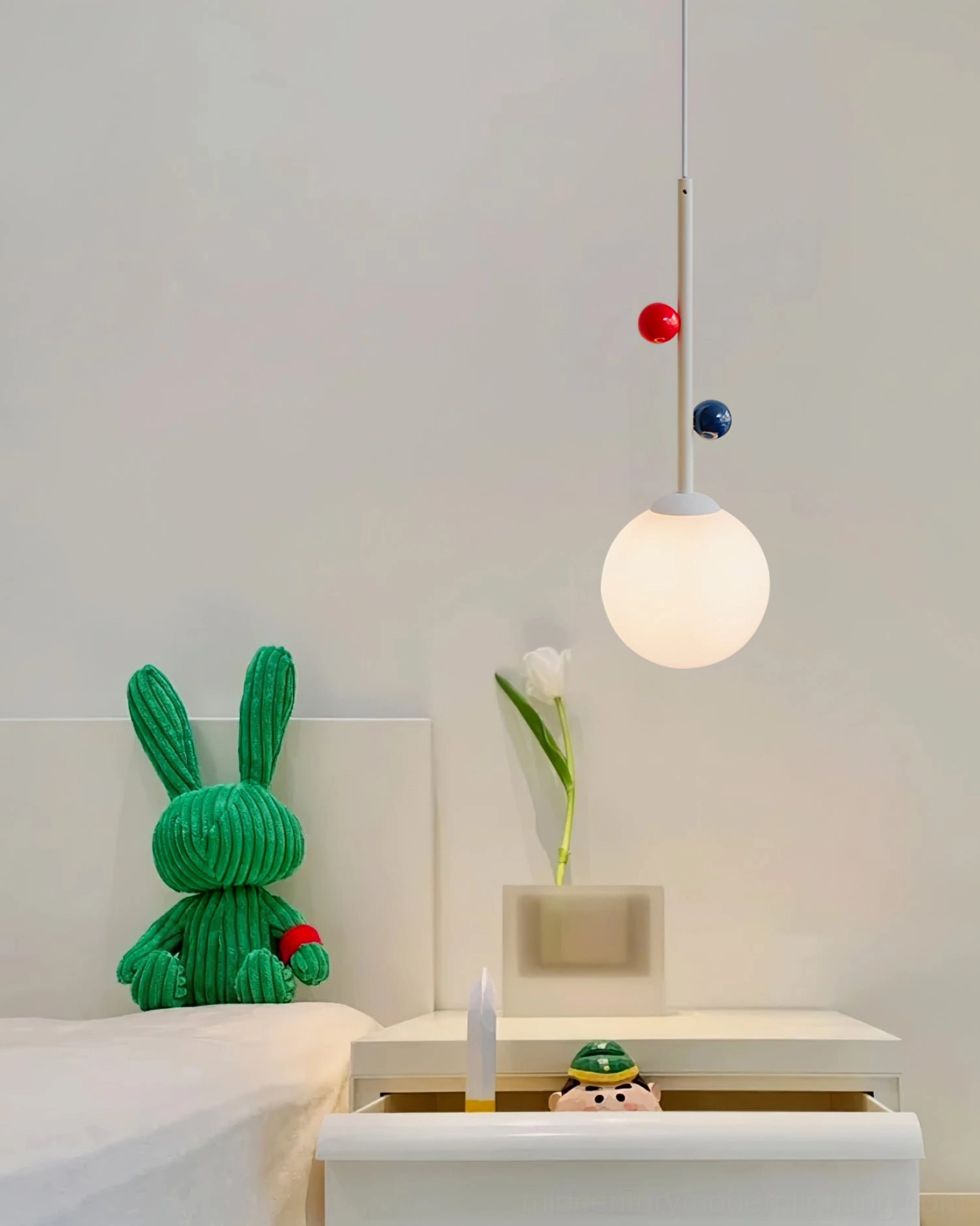 Pair of Stax pendant lamps flanking styled white nightstand with decorative rabbit figurine, bedroom view