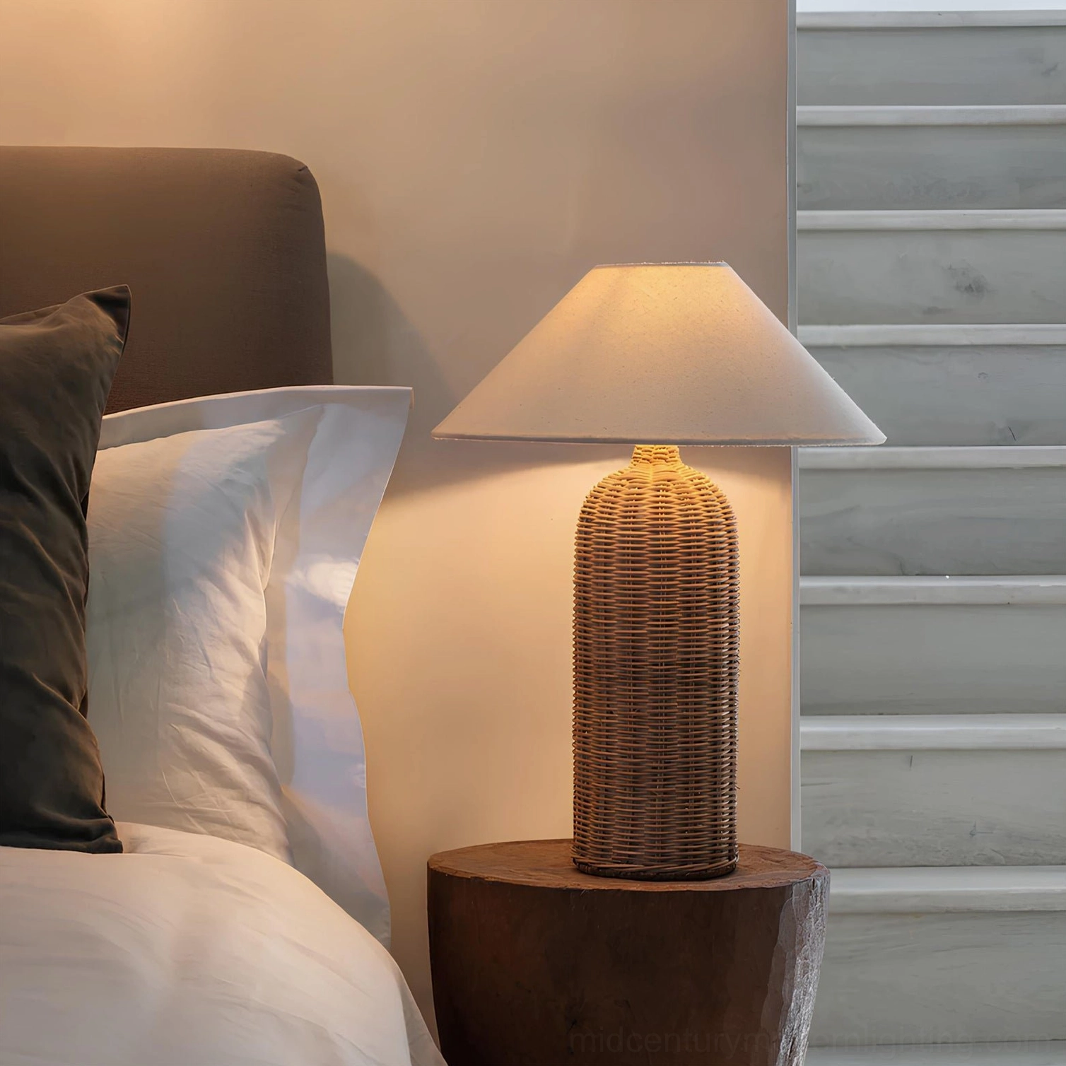 Tall Stellan rattan table lamp placed on bedroom bedside table, creating warm ambient lighting in cozy interior