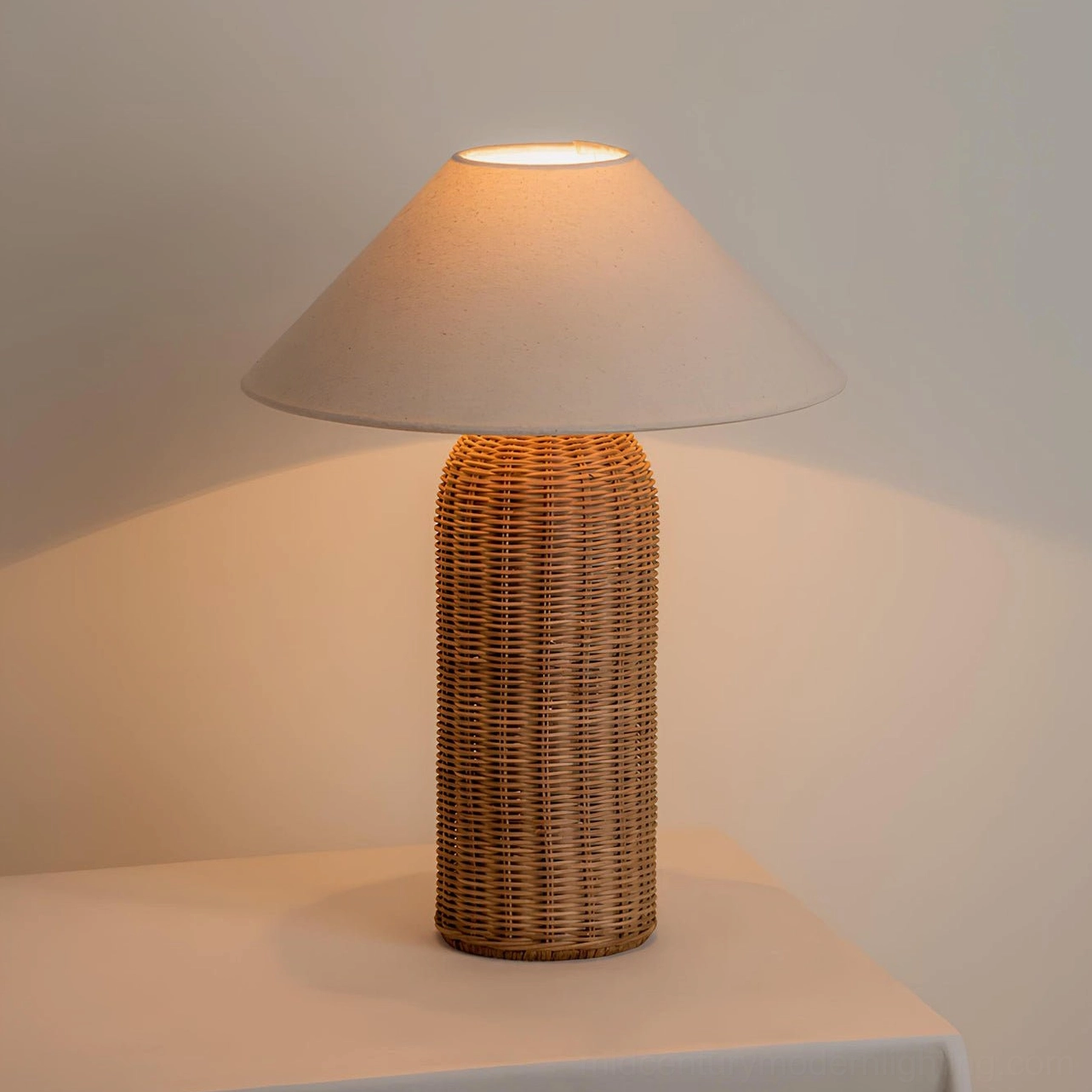 Tall column style Stellan rattan table lamp with tapered fabric shade and woven rattan column base, studio view