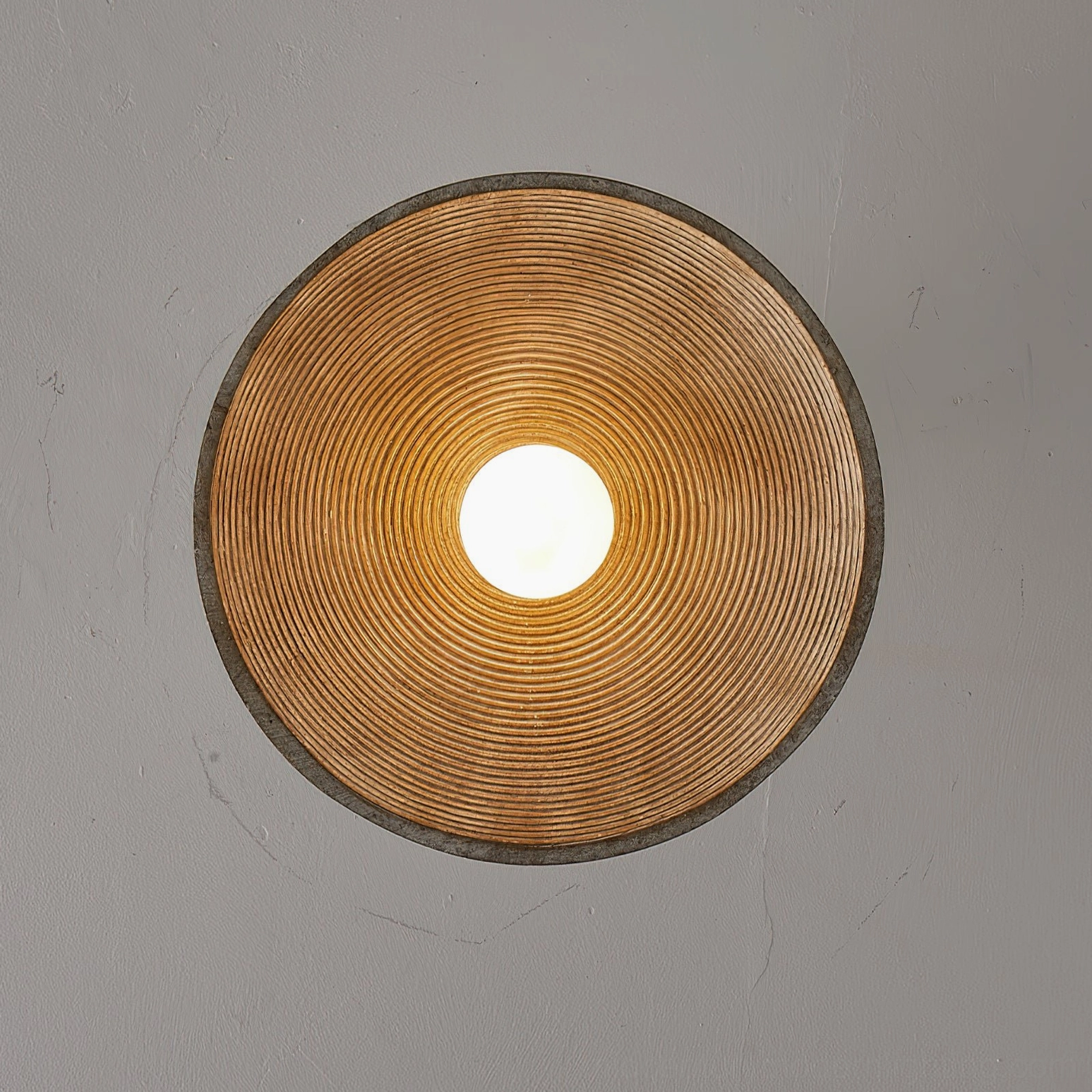 Bottom view of Stevie ceiling light showing concentric ribbed interior shade and glowing bulb from underneath