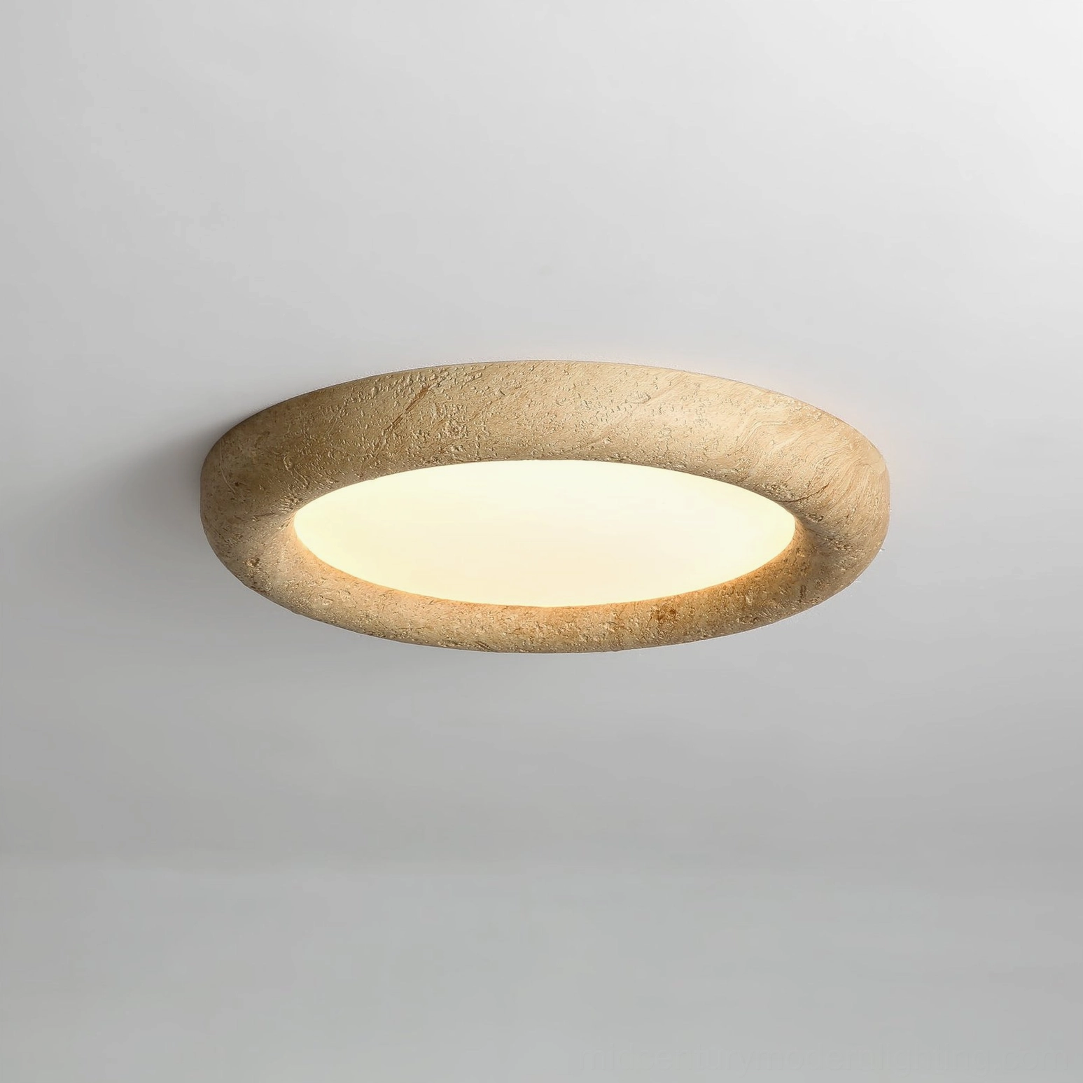 Low-angle view of circular stone ceiling light fixture with textured beige frame on white background