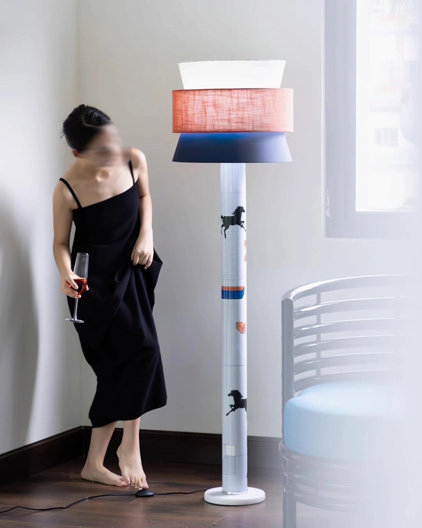 Contemporary floor lamp in minimalist living room corner with wooden floor, woman in elegant black dress pose