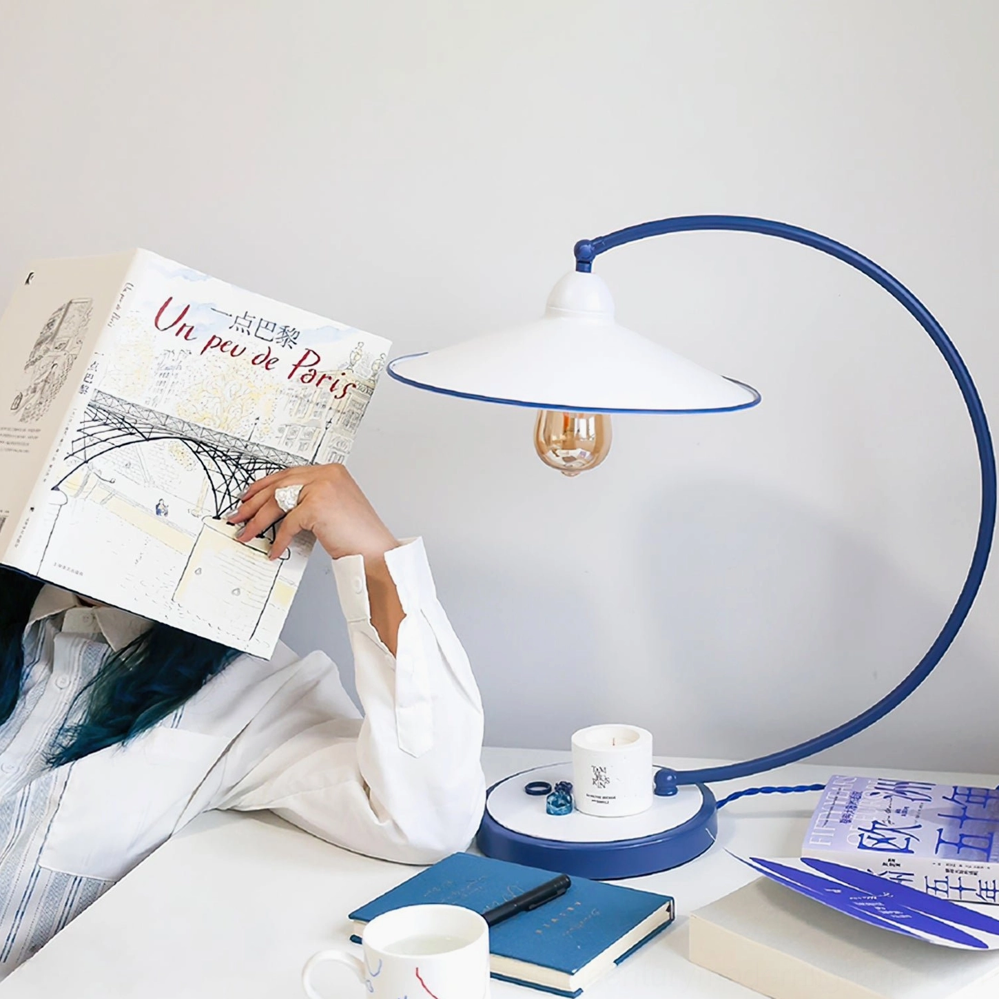 Swan Blue Table Lamp in home office workspace - eye-level side view with desk accessories and stationery
