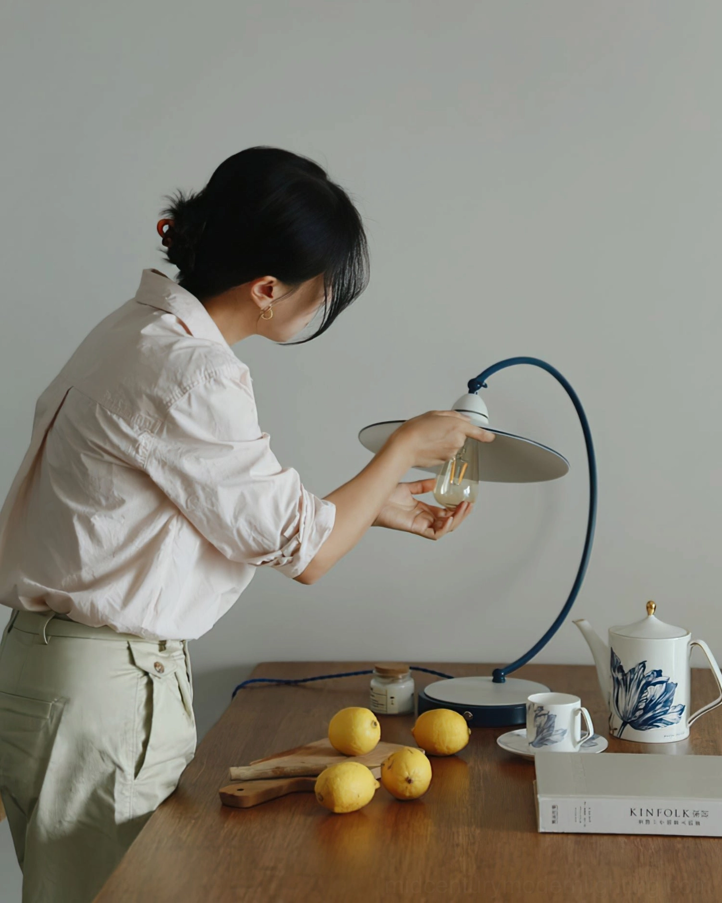 Swan Blue Table Lamp bulb installation - female model adjusting Edison bulb in E26 socket