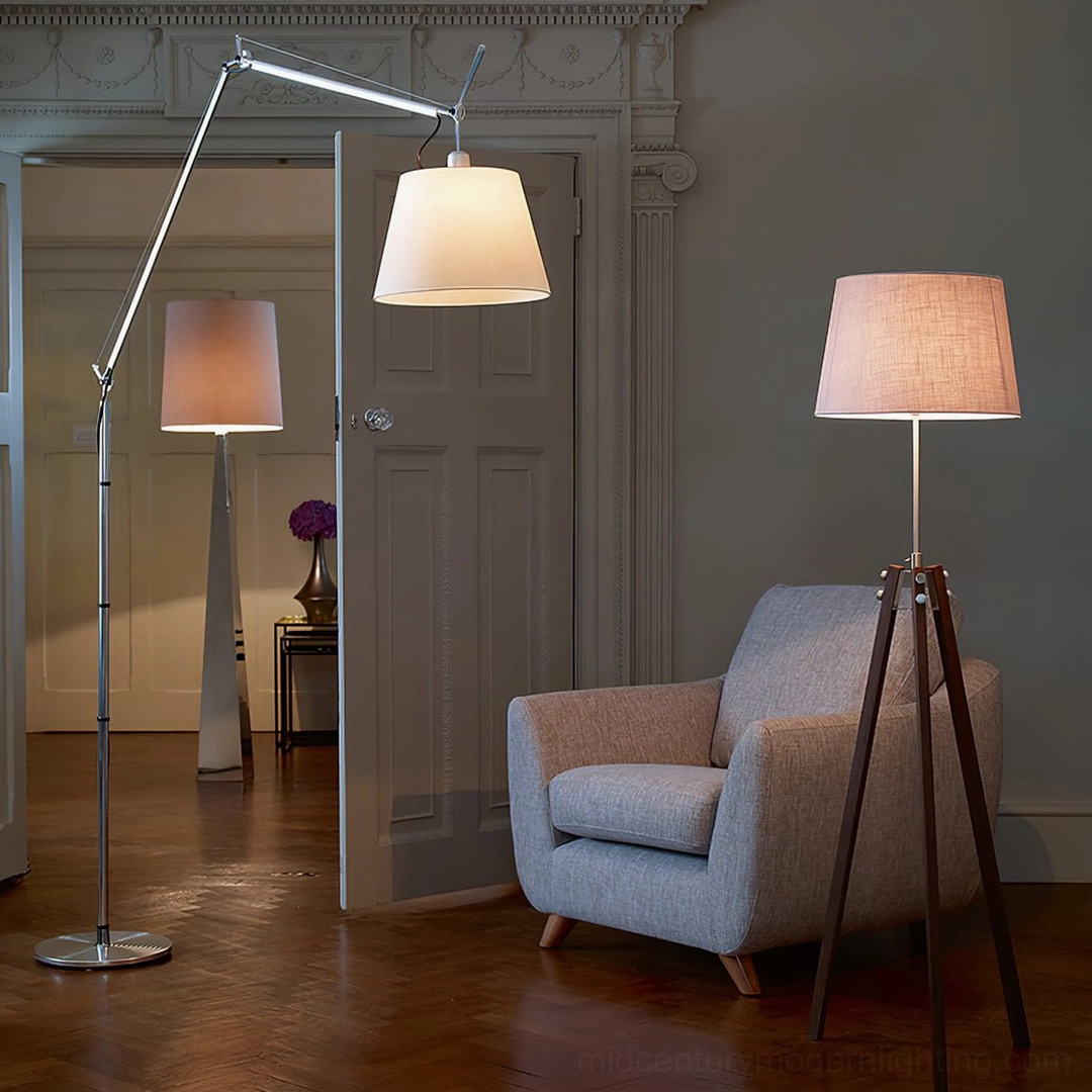 Modern minimalist entryway with silver swing arm floor lamp and complementary tripod wooden floor lamp beside gray armchair
