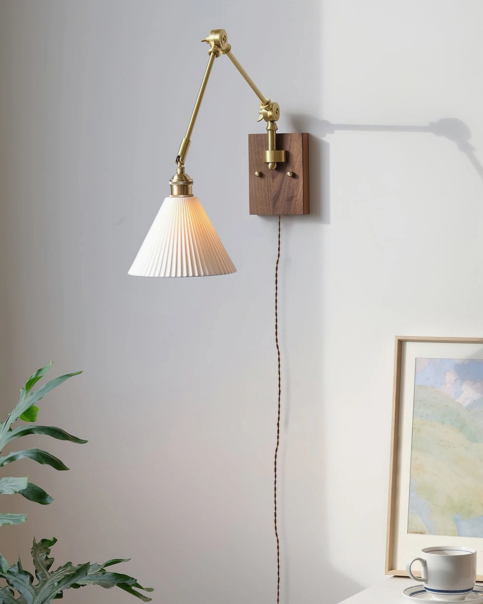 Swing arm plug-in wall lamp with brass arm above side table in modern home decor setting