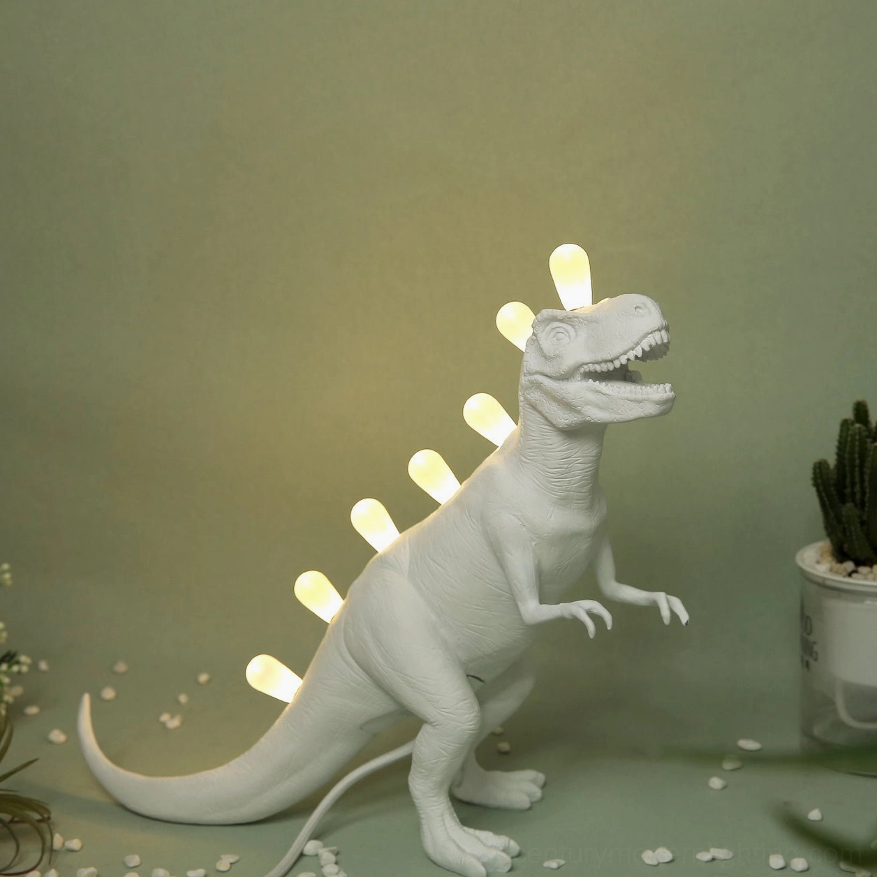 T-Rex dinosaur table lamp with LED spine illumination, front three-quarter view with minimalist décor