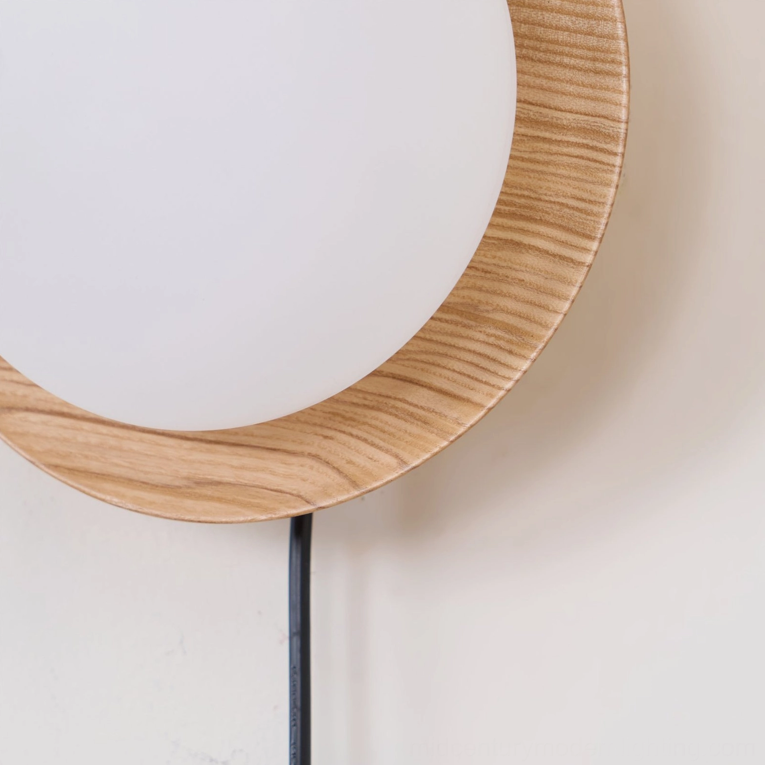 Close-up detail of Tablet wall lamp wood grain ring backing plate with black power cord