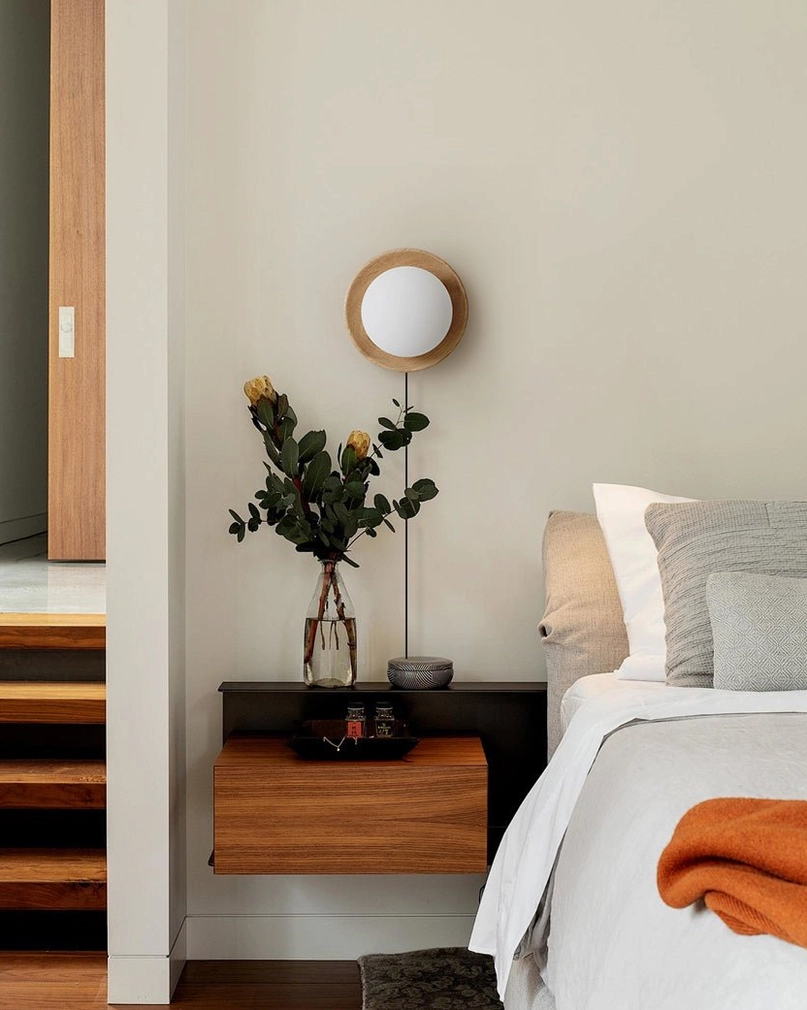 Tablet plug-in wall lamp fixture displaying natural wood grain finish and sculptural glass diffuser