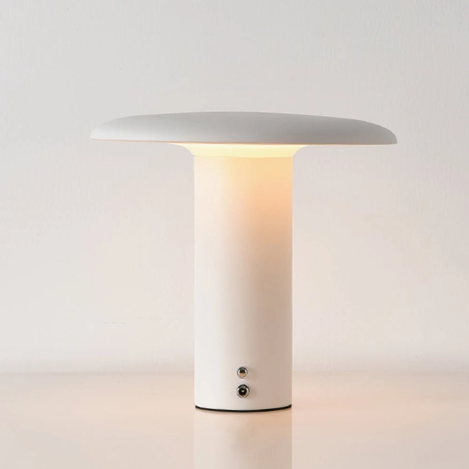 Takku white matte cordless mushroom lamp glowing with warm ambient light on minimalist desk display