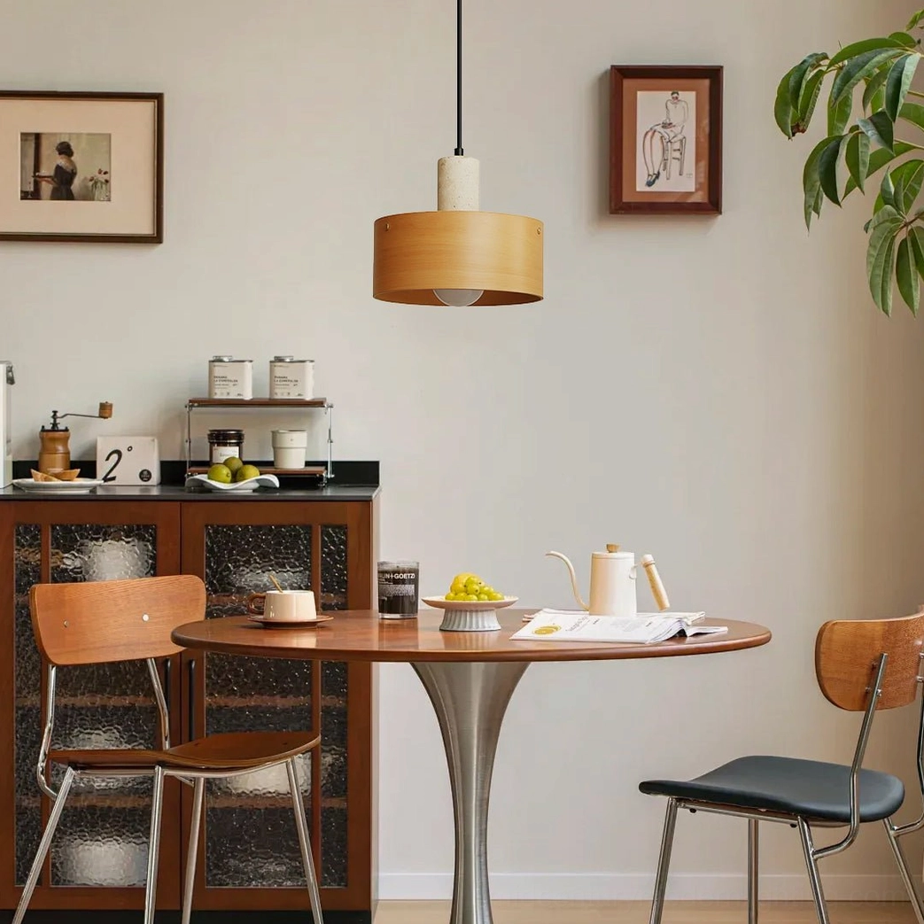 Warm wood-toned Tako pendant lamp hanging over rustic dining table in cozy home setting