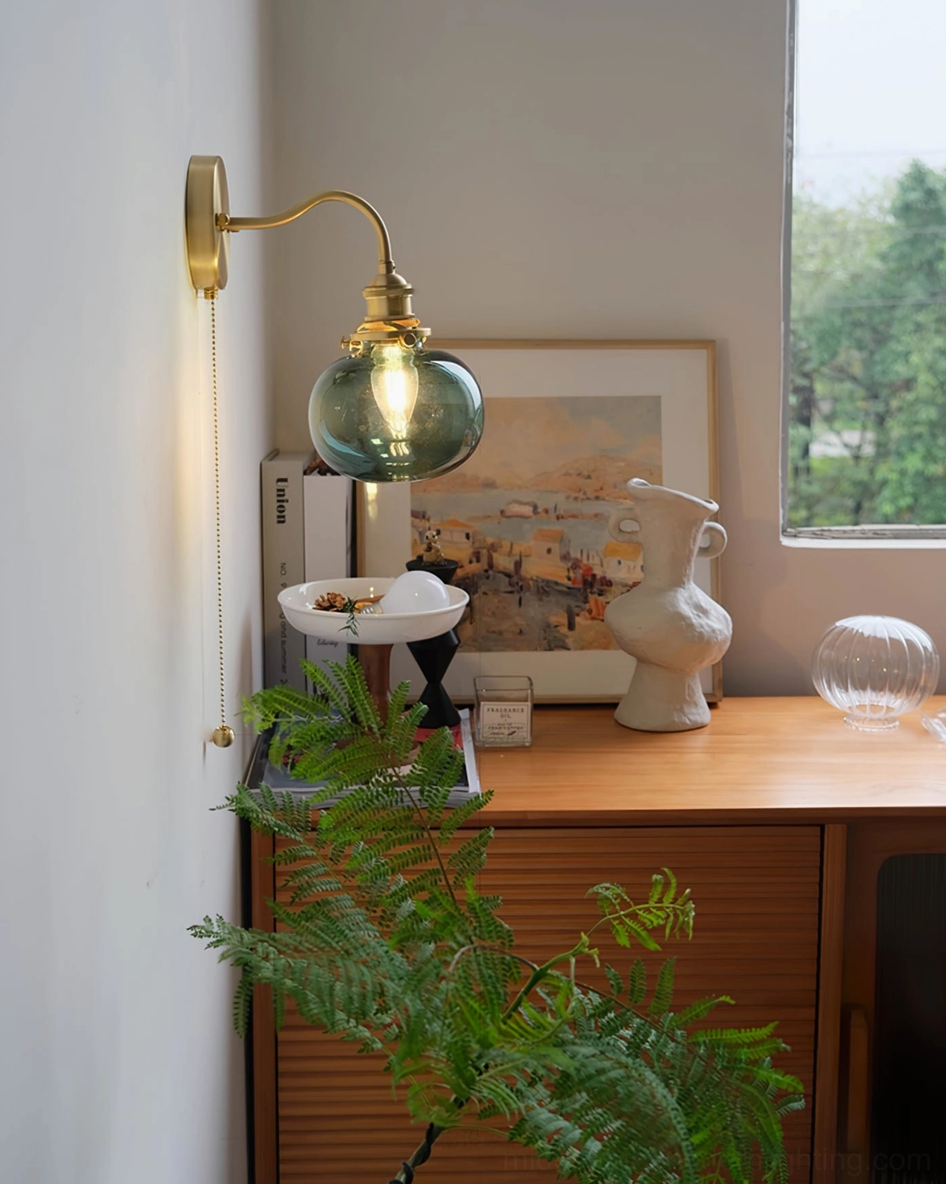 Teal blue glass brass wall sconce with wooden side table and botanical styling - jewel-tone mid-century