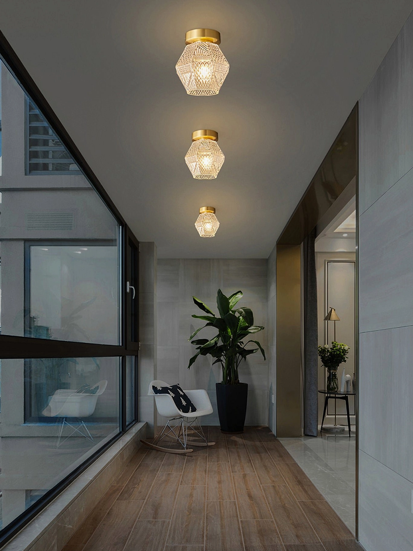 Row of three Art Deco ceiling lights evenly spaced with floor-to-ceiling windows hallway
