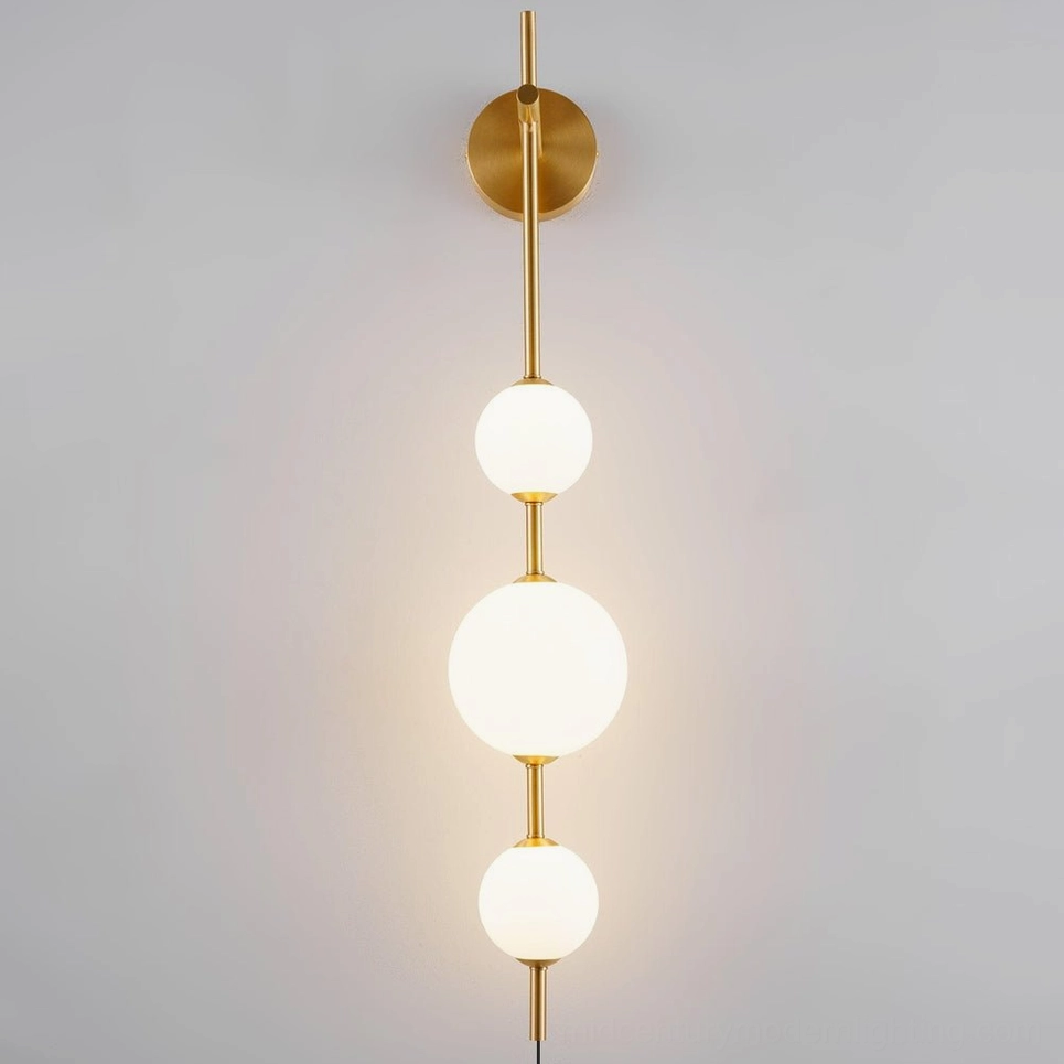 Three-tier vertical globe wall sconce in brass finish, fully illuminated with warm white light