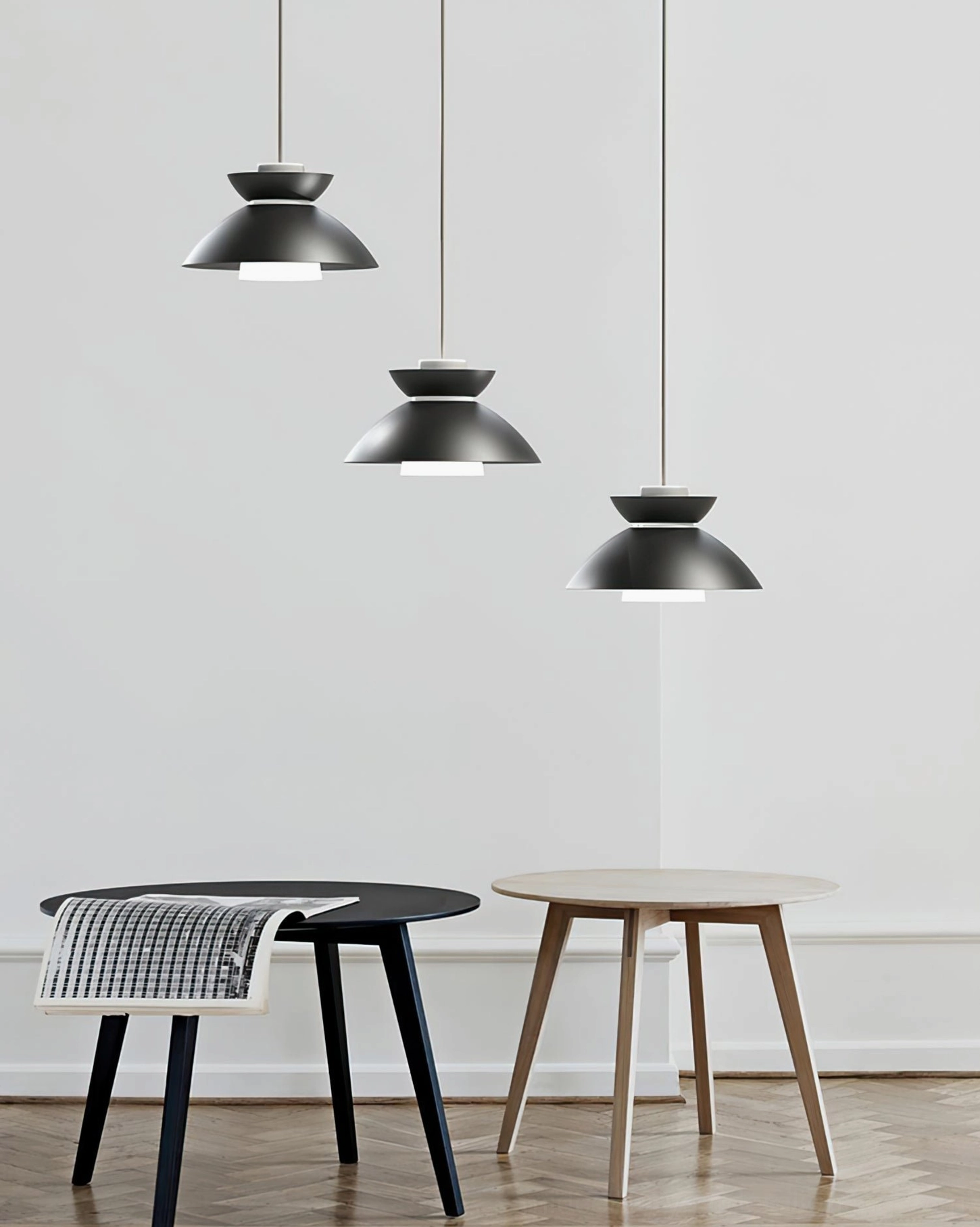 Set of three Hannes matching pendant lamps with uniform matte black design suspended above modern dining table