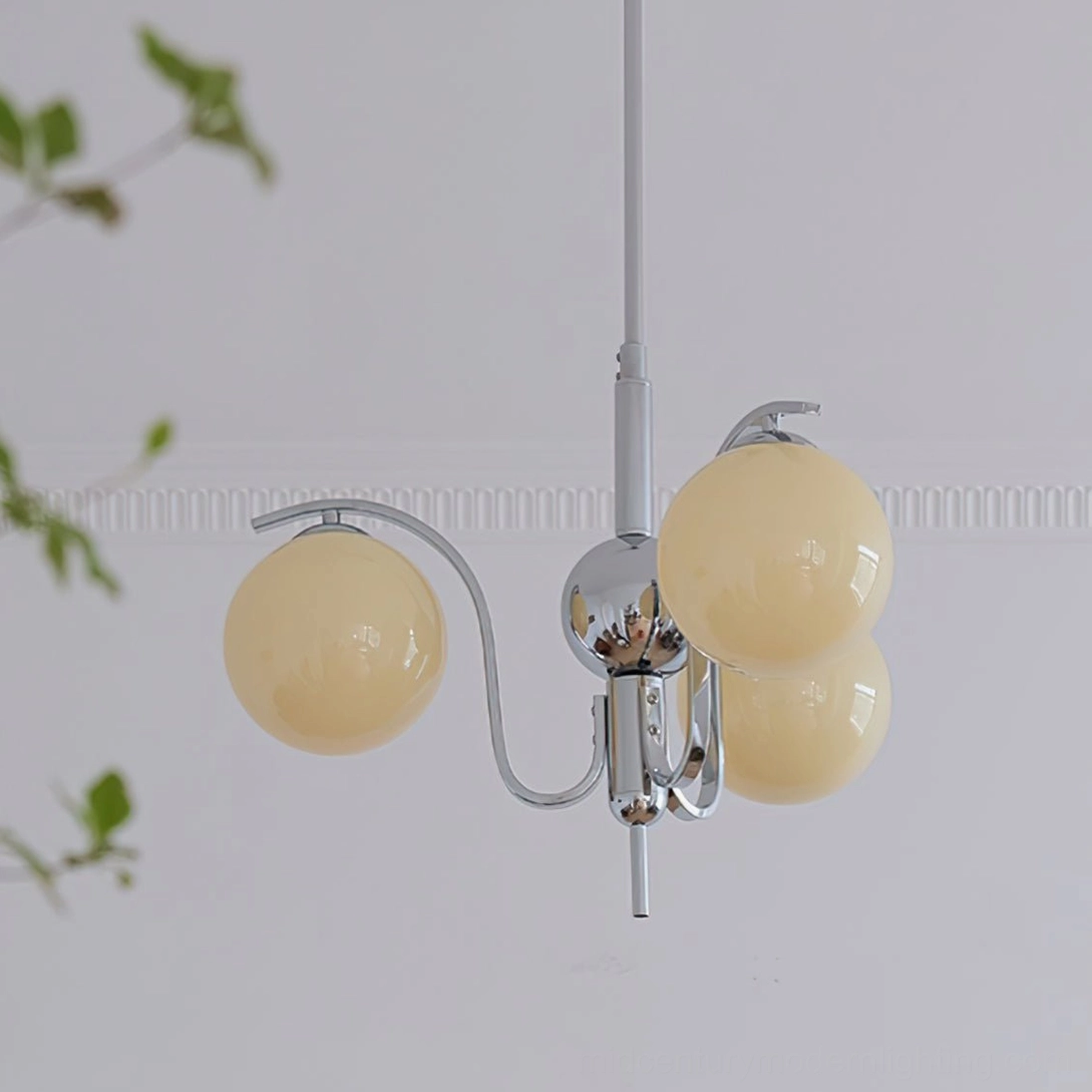 3-head compact glass globe chandelier with beige shades and sleek chrome finish installed in minimalist space