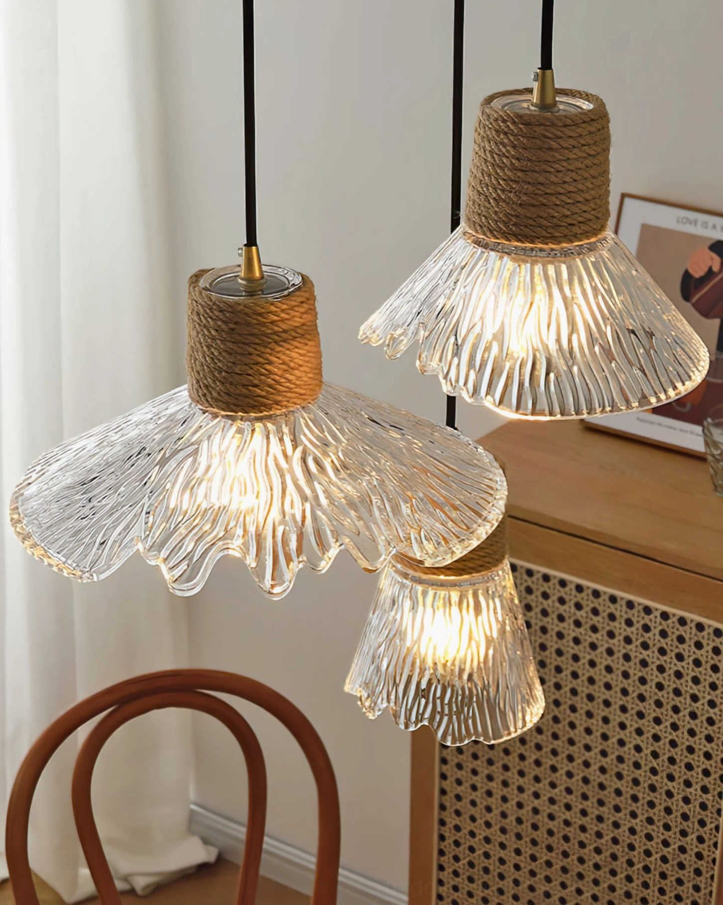 Three hemp rope glass pendant lamps clustered together in living area, demonstrating layered lighting design and warm glow effect