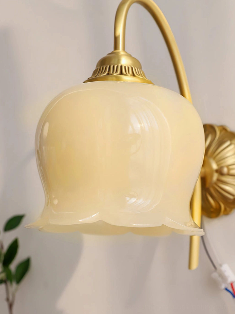 Lily of the valley wall lamp three-quarter view highlighting brass fixture and cream glass shade