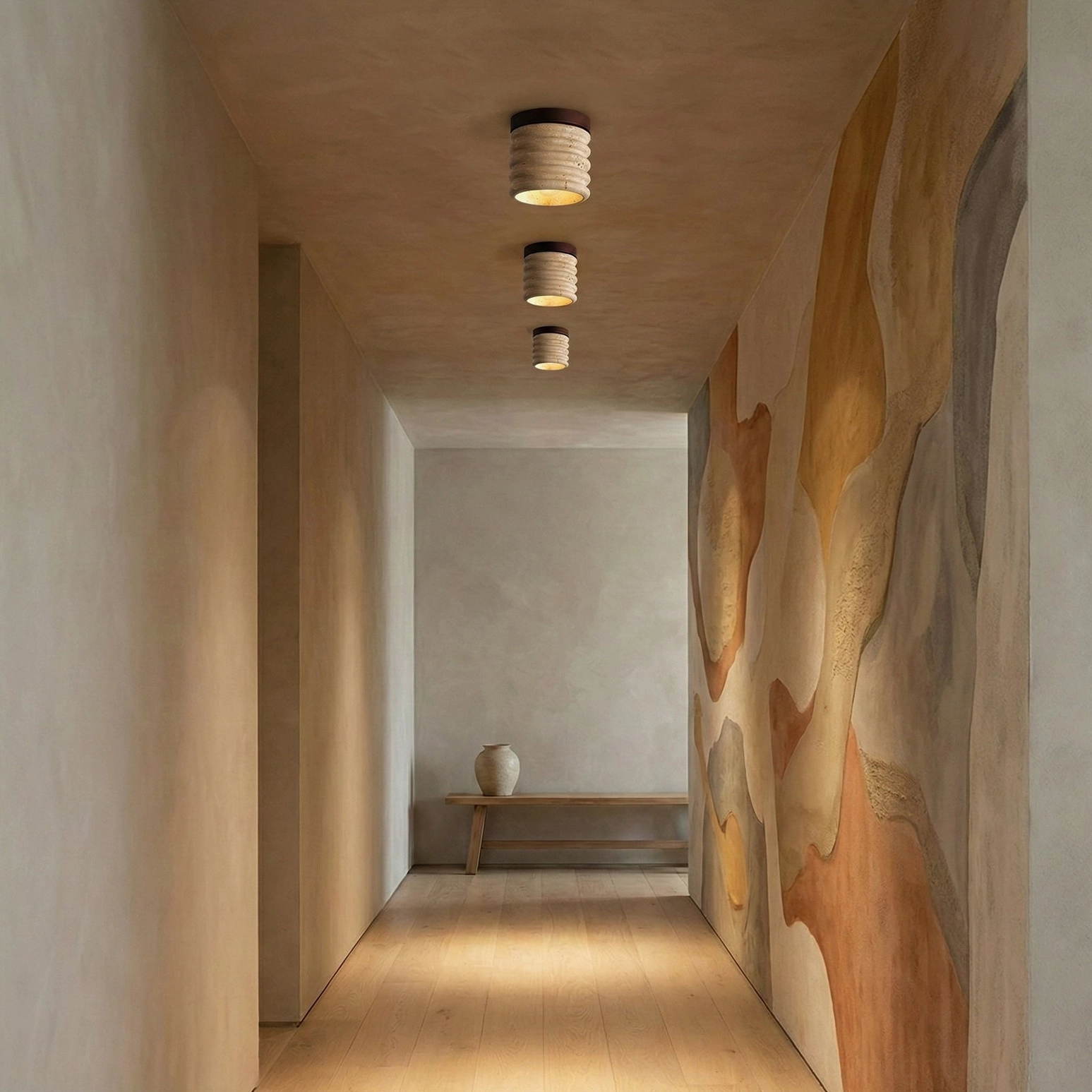 Trio of travertine ceiling lamps installed in art-focused residential hallway, minimalist warm tone
