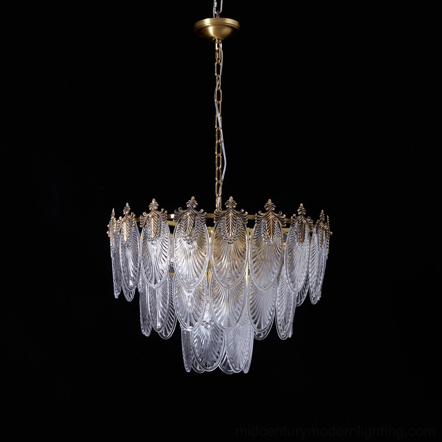 Three-tier brass chandelier suspended in transitional interior, showing soft golden glow and proportional brass ring structure