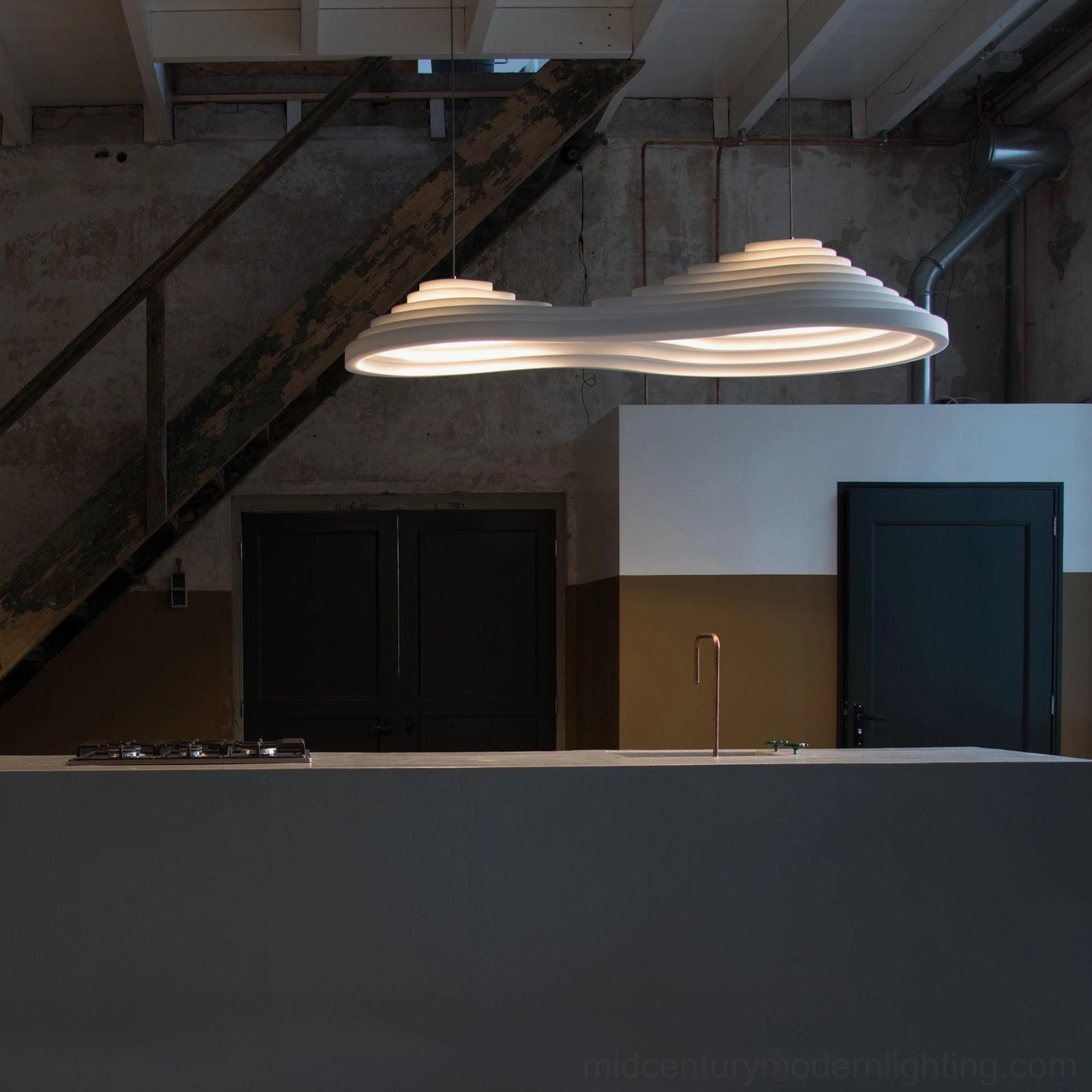 Organic tiered pendant fixture in industrial loft kitchen showing sculptural form and raw architectural style
