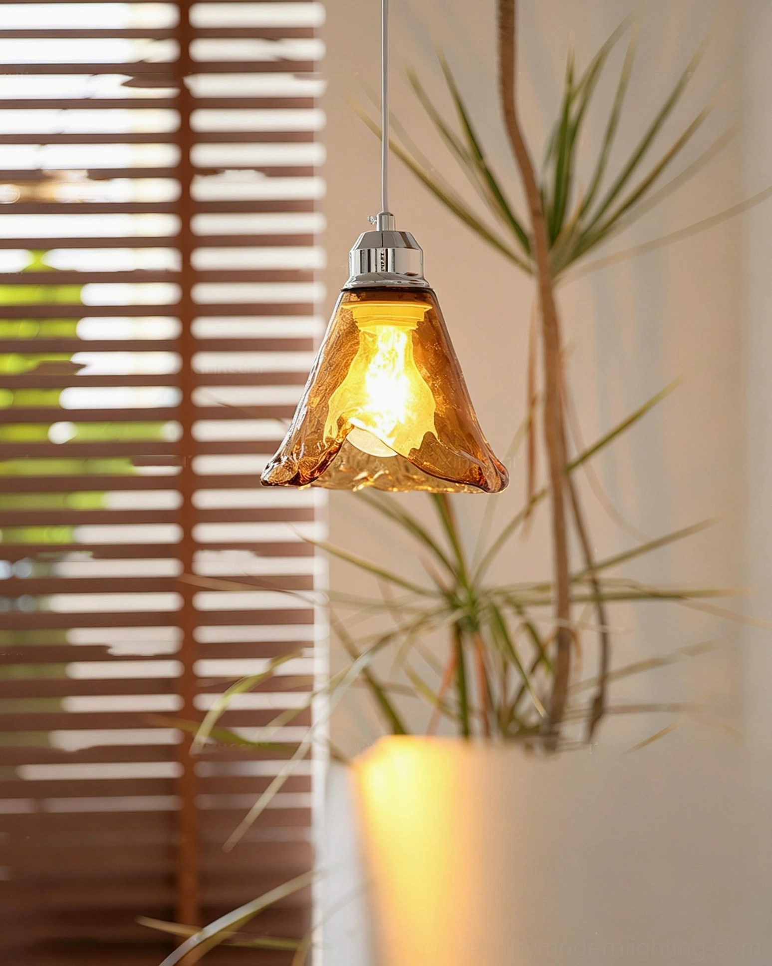 Hand-blown Tiro glass pendant shade with irregular wavy texture in indoor space with natural window light