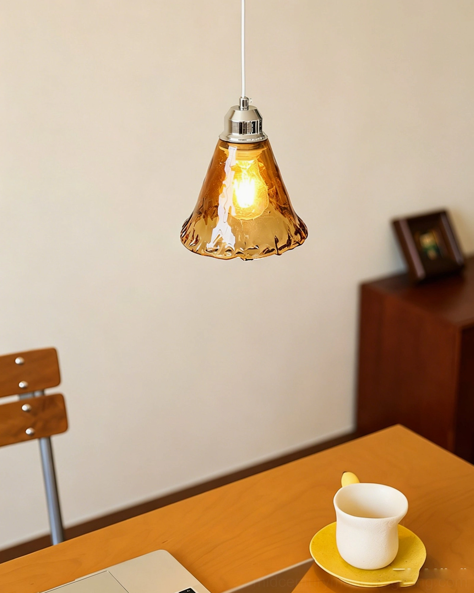 Tiro amber glass pendant light overhead view above dining desk, compact warm-toned shade with tableware
