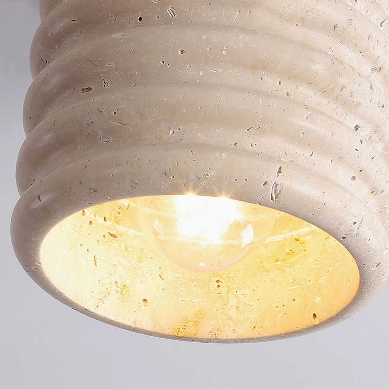 Travertine ceiling lamp in residential space showing textural sculptural design element