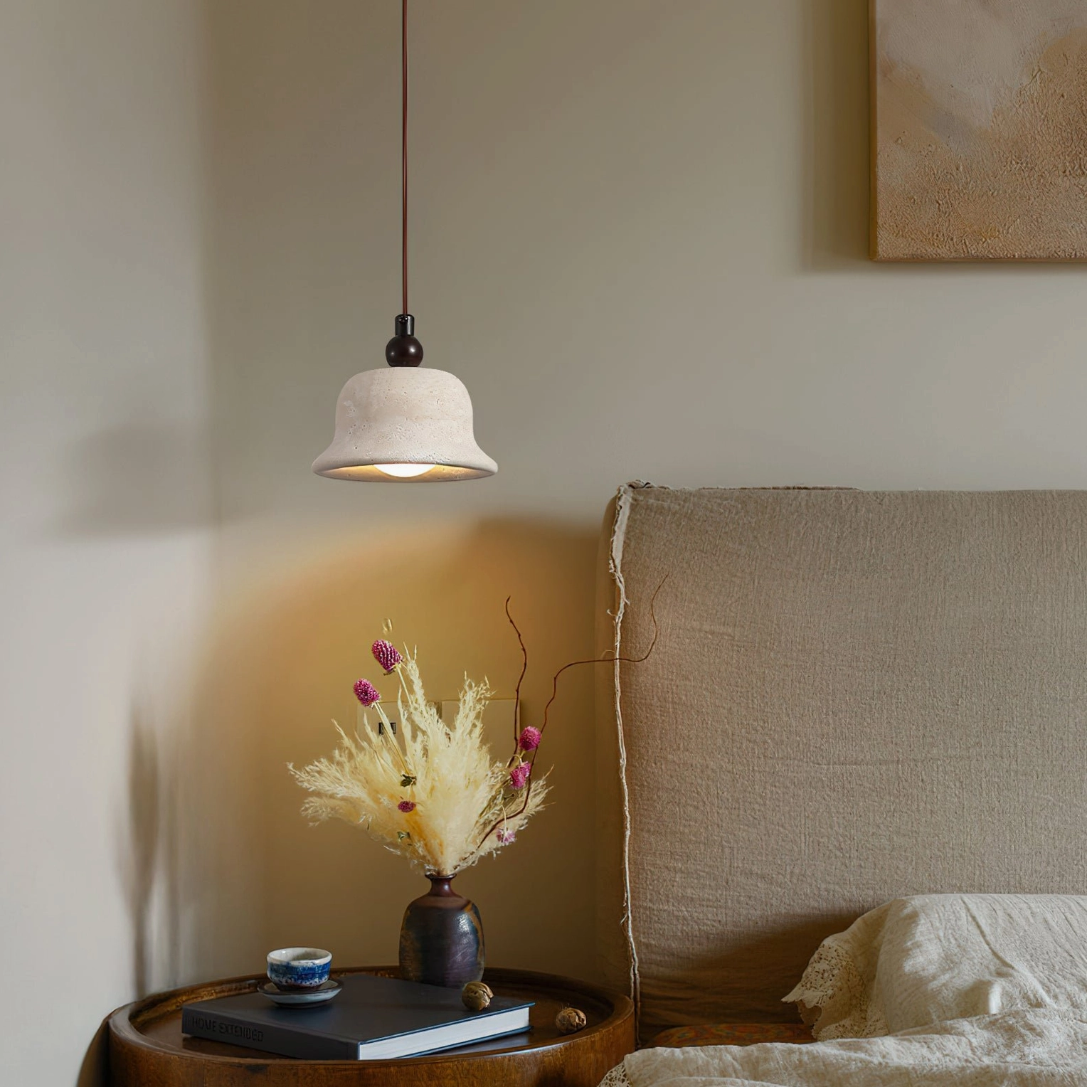 Bedside pendant lamp creating warm ambient glow in minimalist bedroom setting