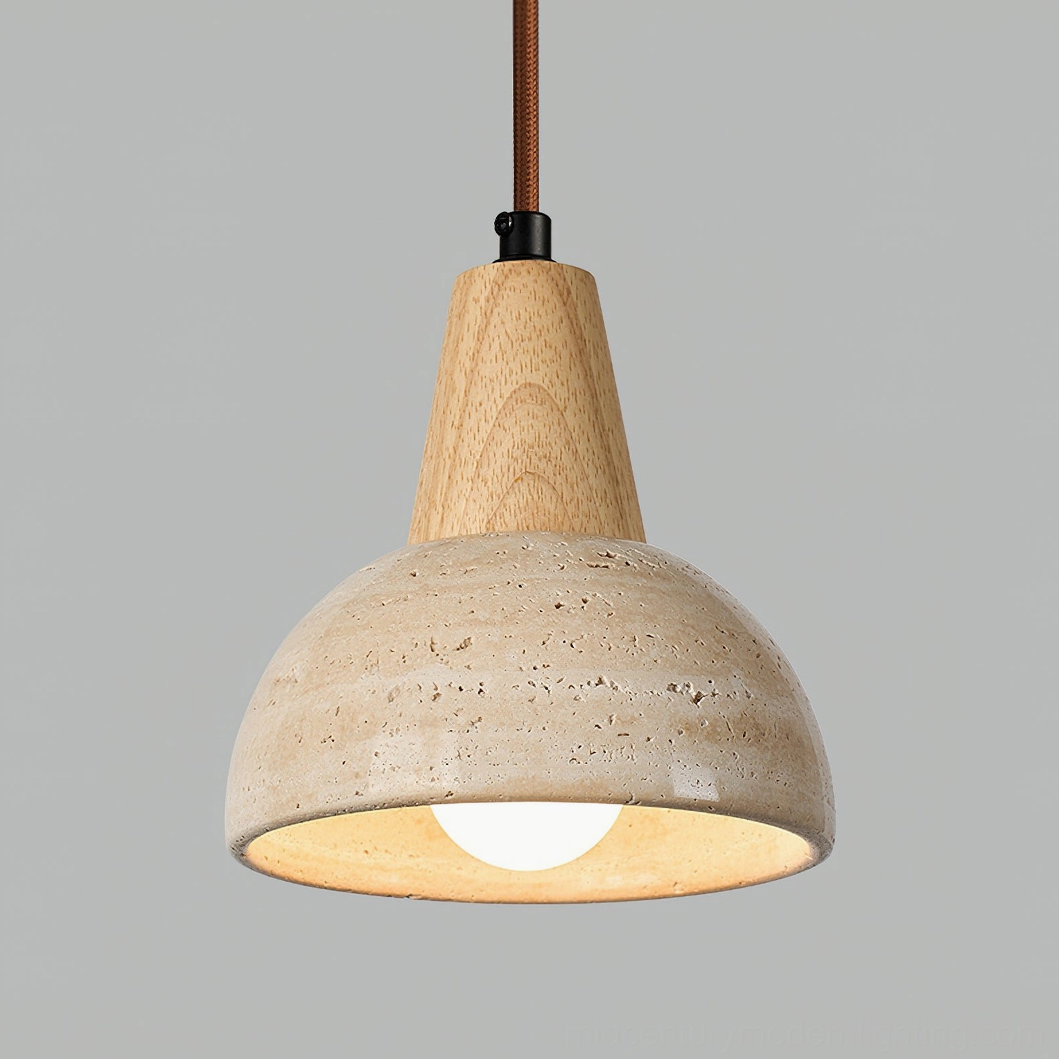 Front close-up of travertine dome pendant lamp with exposed glowing Edison bulb and natural stone details
