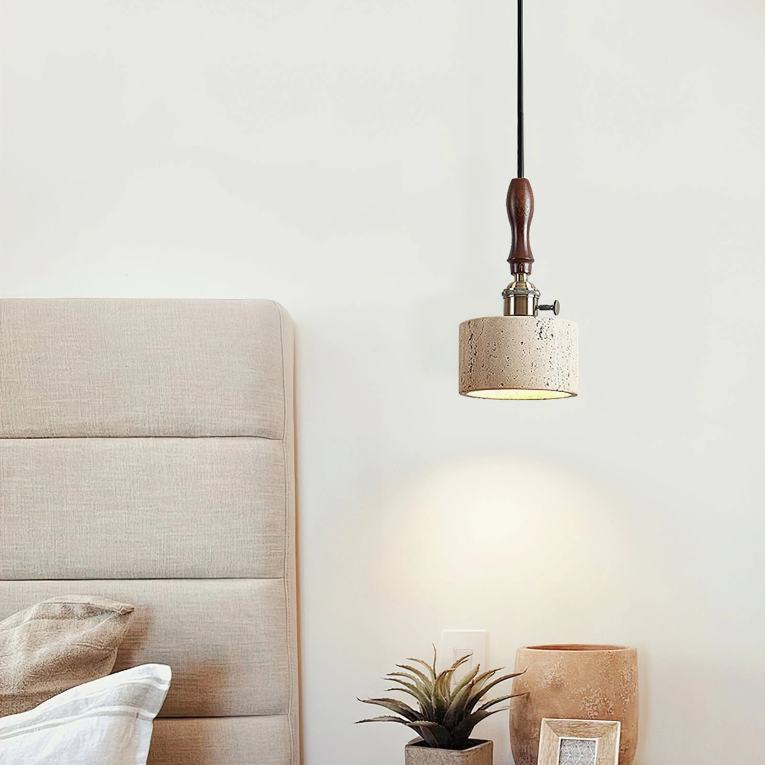 Travertine pendant light styled in boho bedroom with tufted headboard and minimalist decor