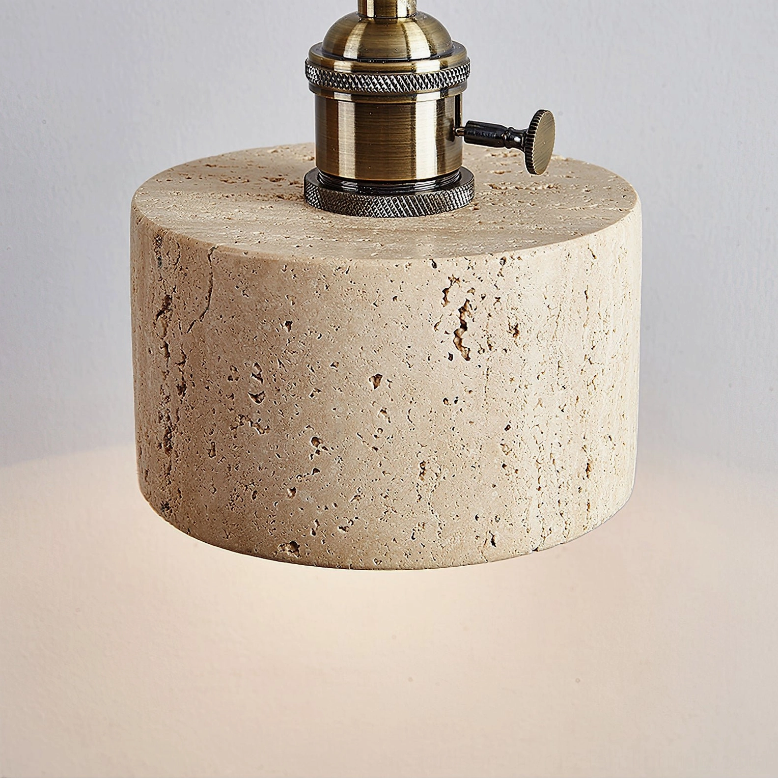 Close-up top view of travertine pendant light showing detailed porous natural stone texture
