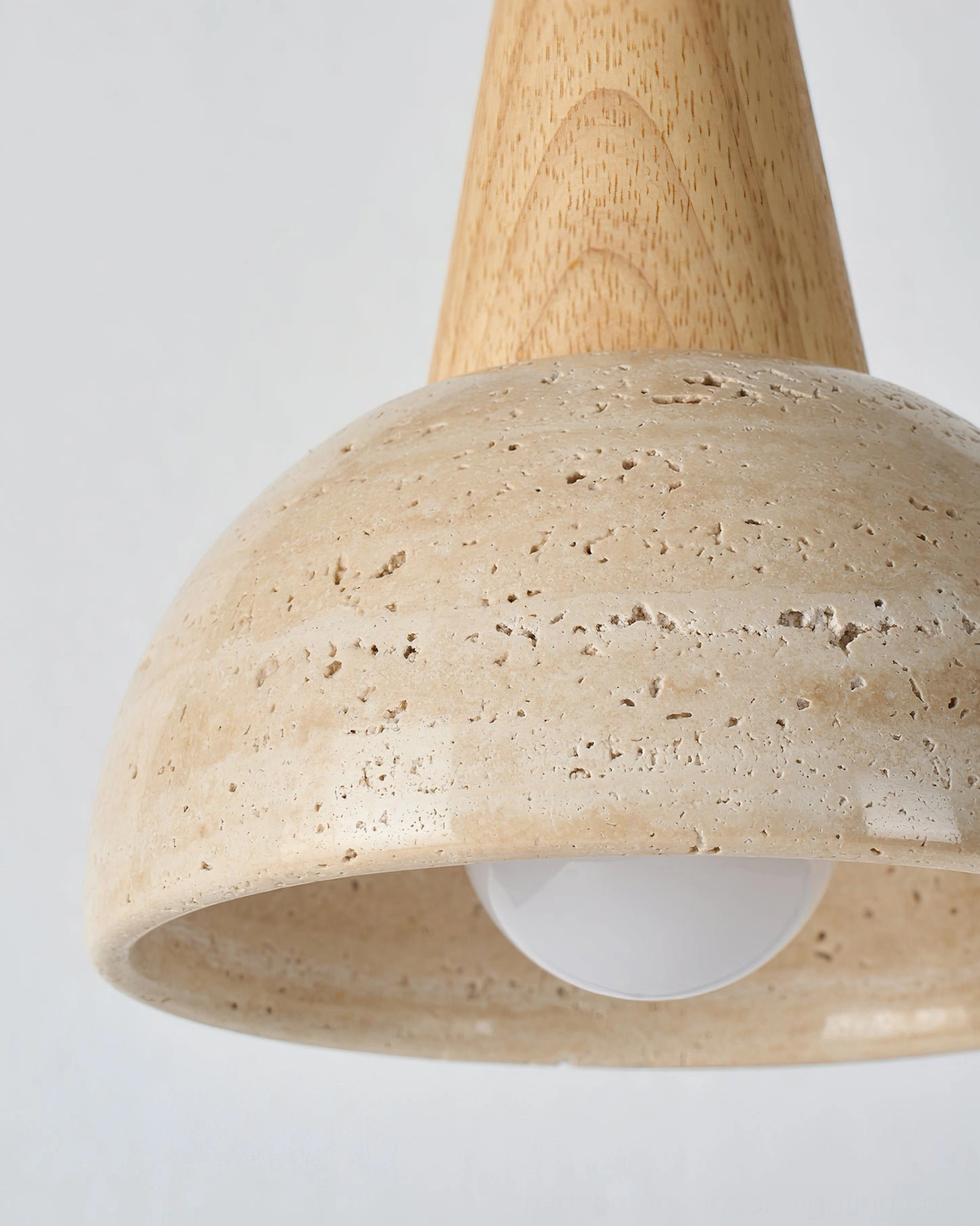 Detailed front view of travertine pendant light showing porous stone surface and light diffusion on white background