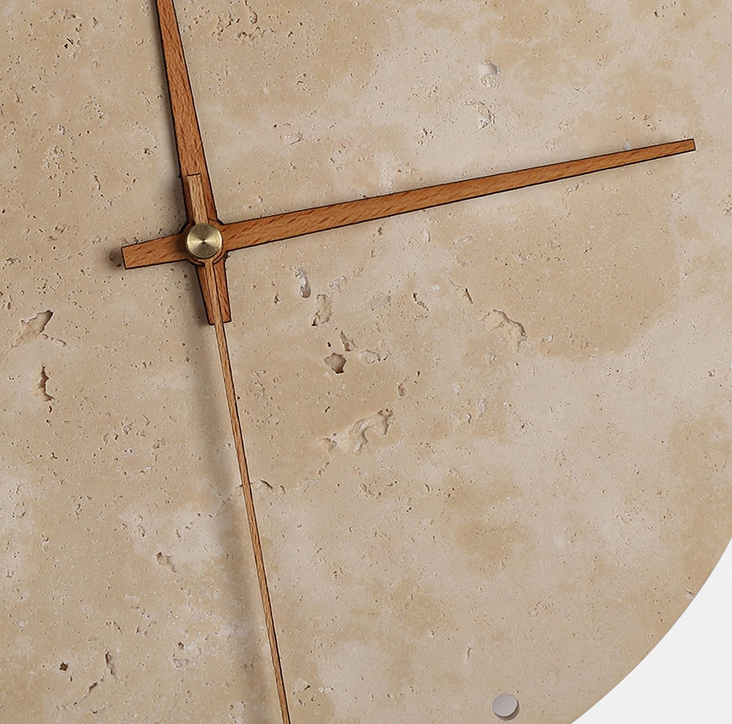 Close-up detail of travertine clock lamp showing wooden hands, brass joints, and natural porous stone texture