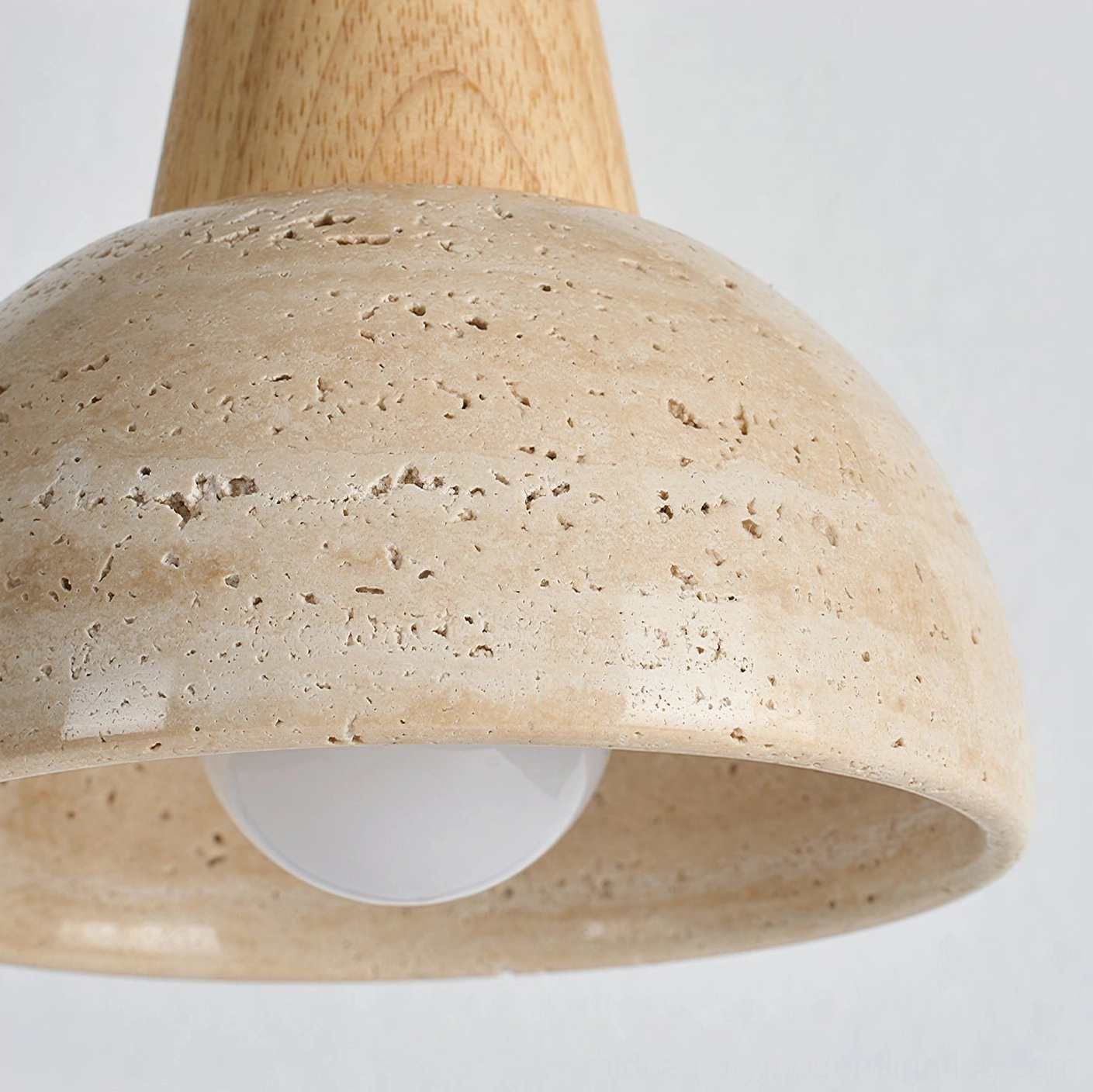 Travertine dome pendant lamp with wood accent trim and natural stone finish in clean studio photography